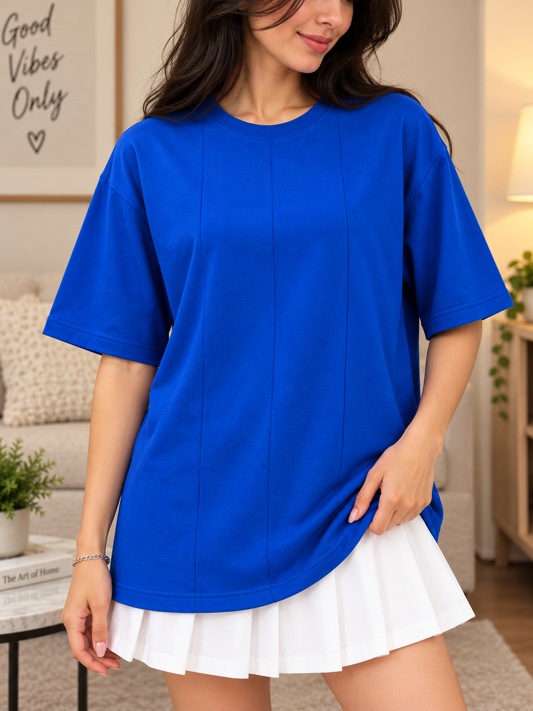 Close-up of a woman wearing a WOMEN BOXY FIT PANELS OVERSIZED T-SHIRT BLUE with a white skirt, showcasing a casual style.