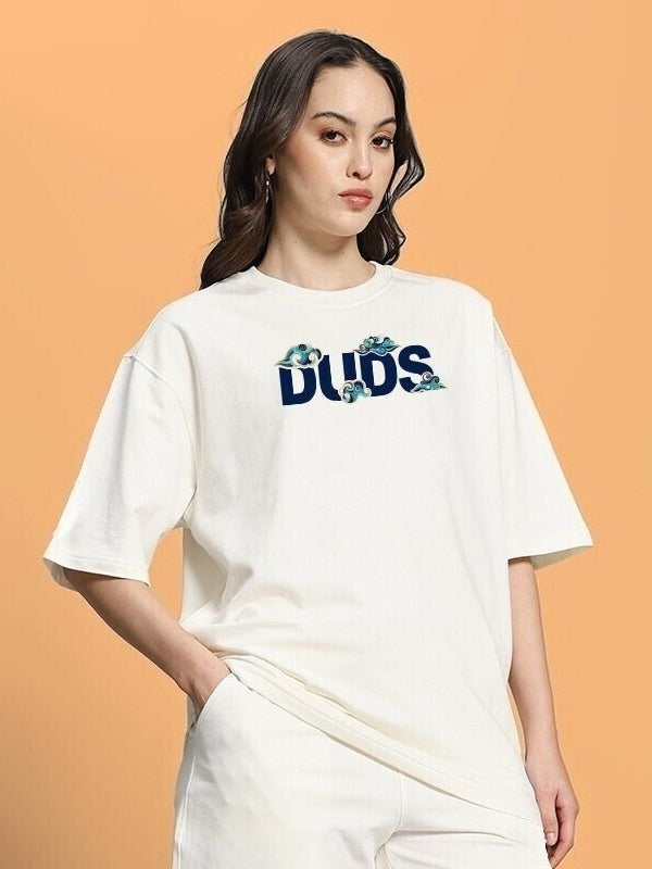 Woman wearing WOMEN CLOUD PRINTED OVERSIZED T-SHIRT OFF WHITE with cloud design, standing against an orange background.