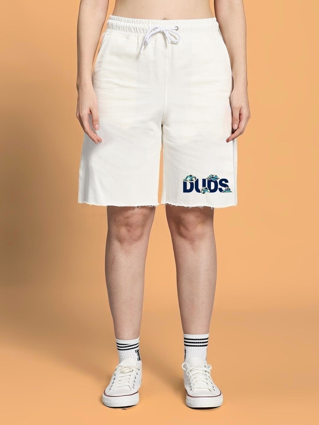 Woman wearing WOMEN CLOUD PRINTED RELAXED FIT SHORTS OFF WHITE with sneakers, showcasing comfort and style.