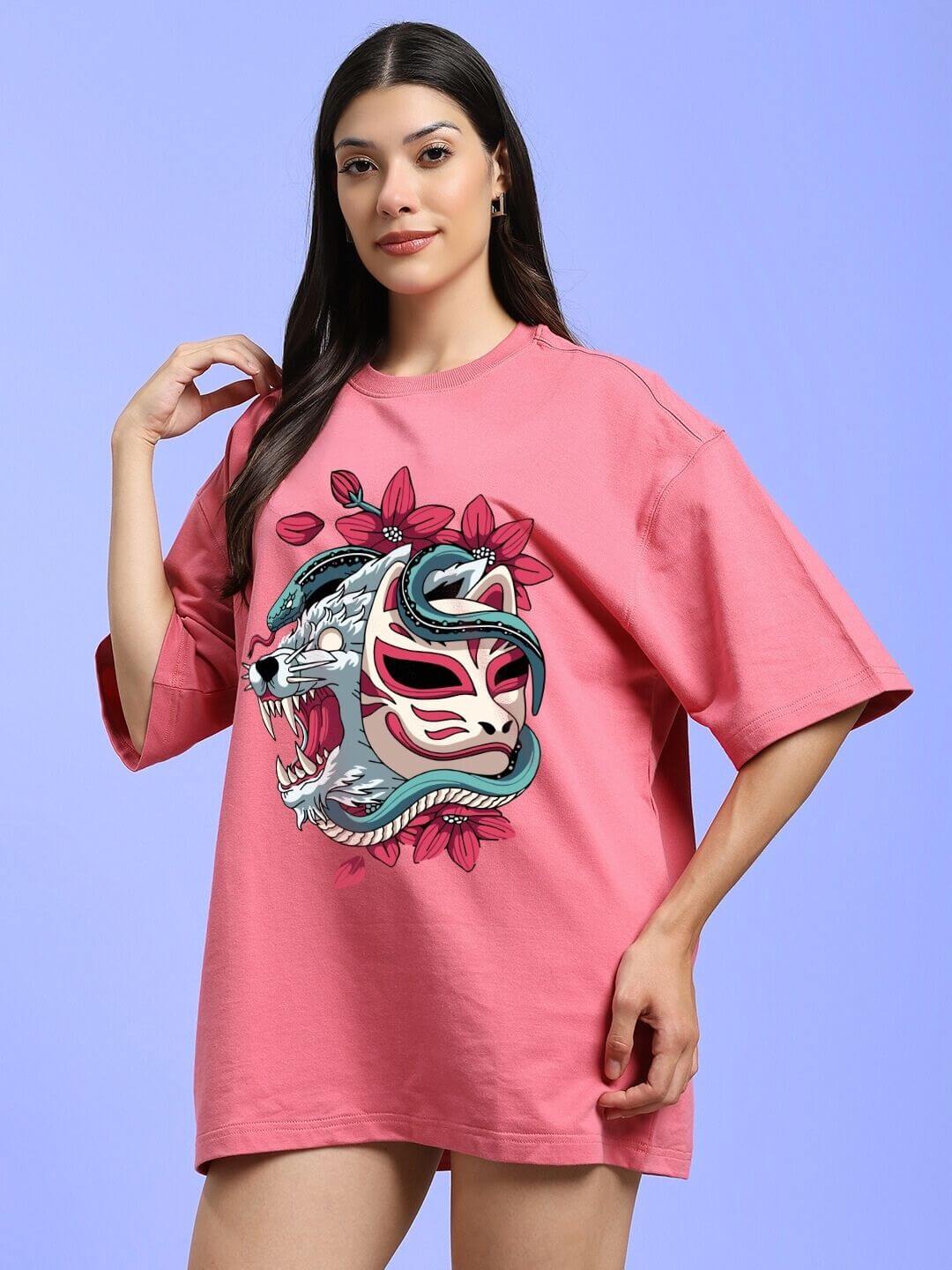 Model wearing WOMEN KITSUNE WOLF PRINTED OVERSIZED T-SHIRT PINK with bold wolf graphic on pastel pink fabric.