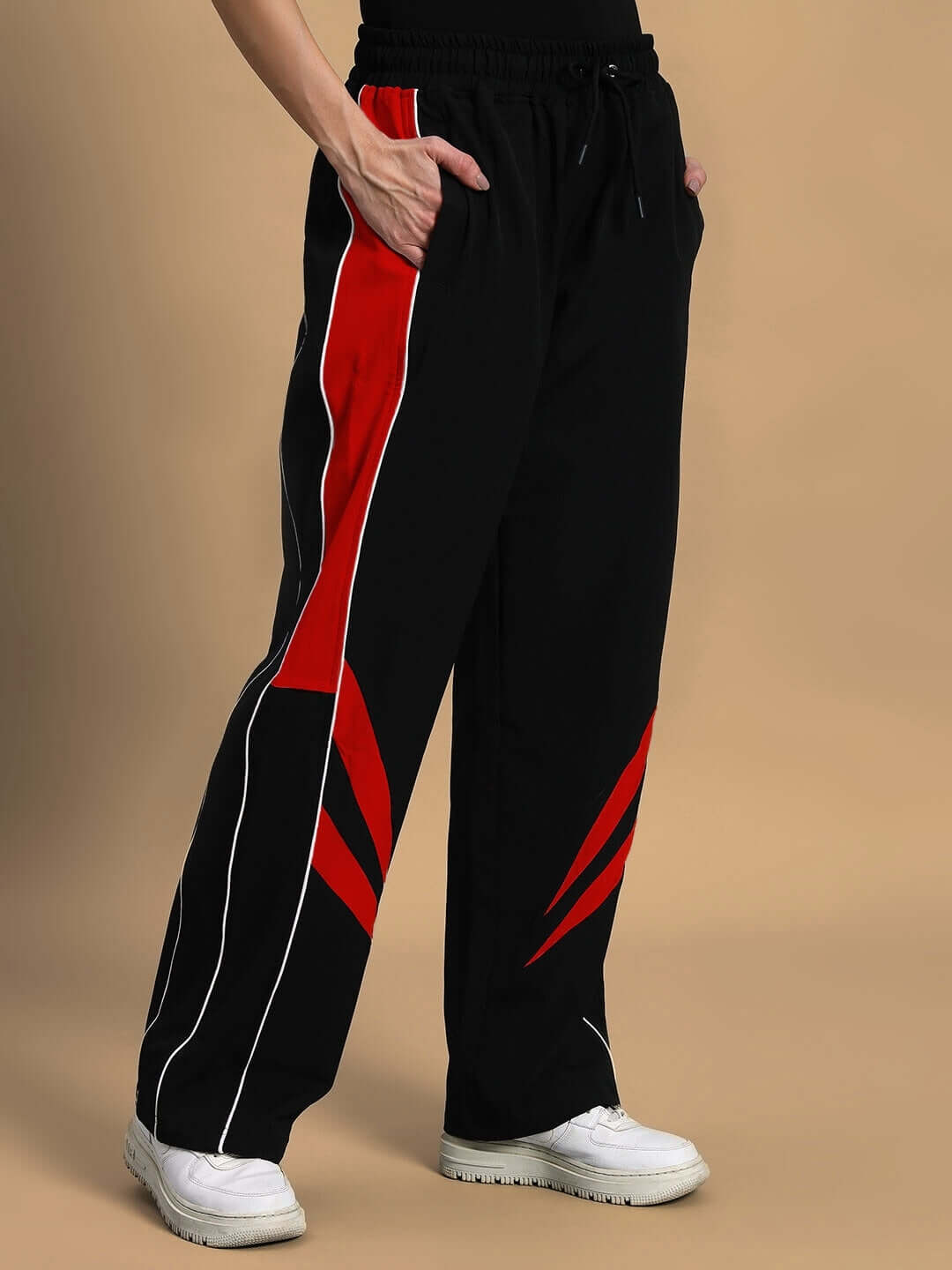 Women's versatile black-red parachute cargo pants, featuring customizable fit for personalized style, shown with white sneakers.