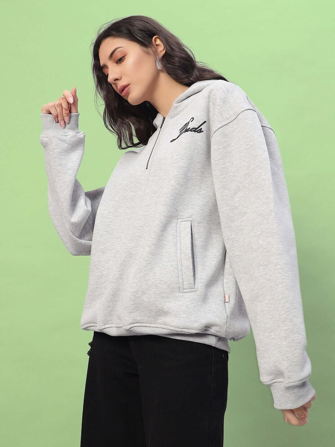 Model wearing WOMEN AMARILLO FLEECE HOODIE MELANGE GREY against a green background