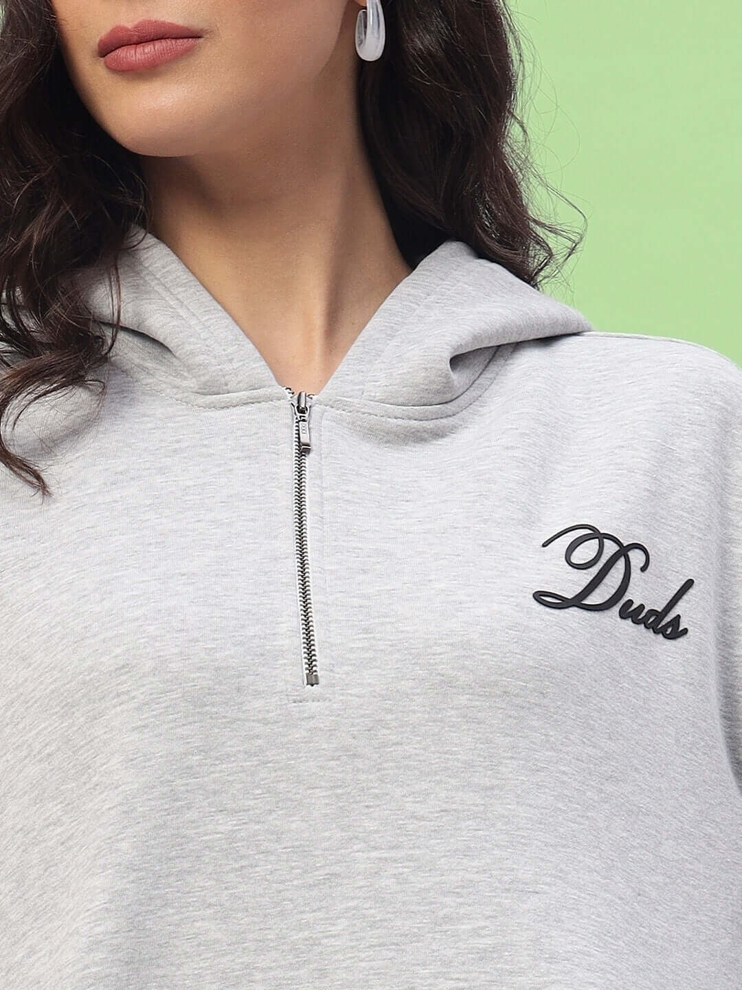 Close-up of a WOMEN AMARILLO FLEECE HOODIE MELANGE GREY with a zipper and 'Duds' logo on the chest.