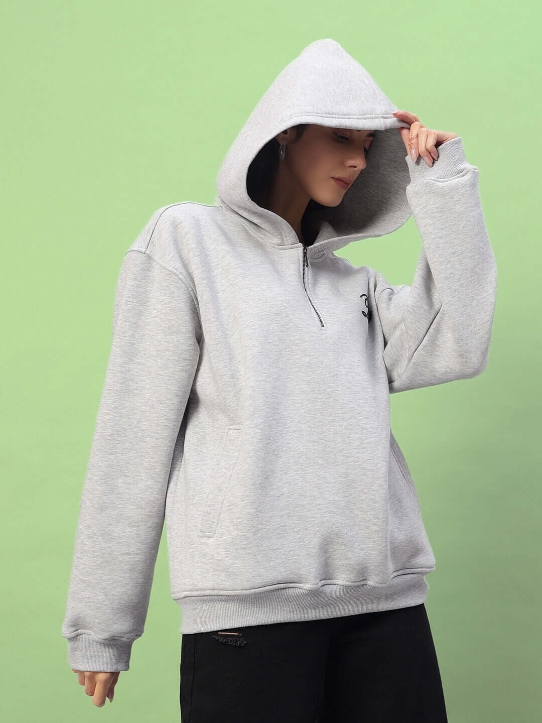 Model wearing WOMEN AMARILLO FLEECE HOODIE MELANGE GREY against a green background.