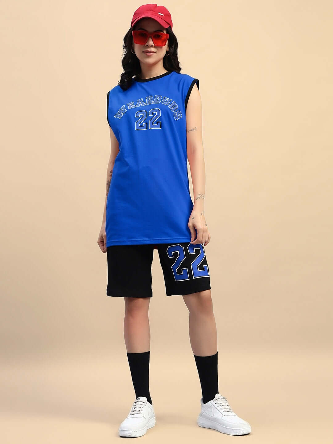 Model wearing WOMEN'S AMIGA Regular Fit Shorts in black-blue with a sporty ensemble, featuring tee and accessories, casual look.