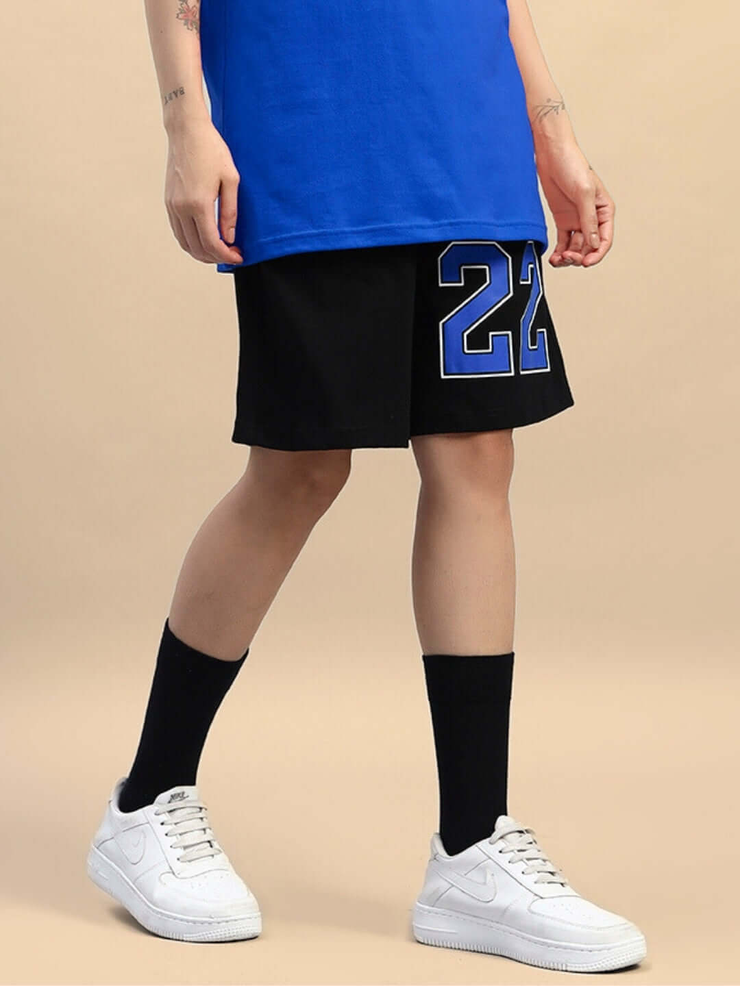 Women's Amiga regular fit black-blue shorts with custom fit option, sports number detail, paired with white sneakers.