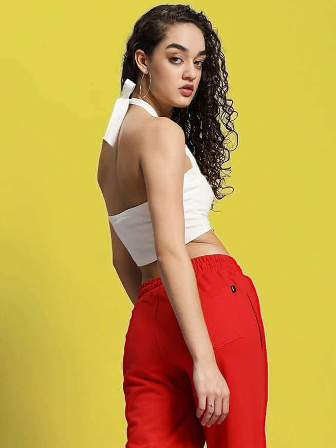 Model wearing WOMEN'S ANISSA CROP TOP OFF WHITE with red pants against yellow background