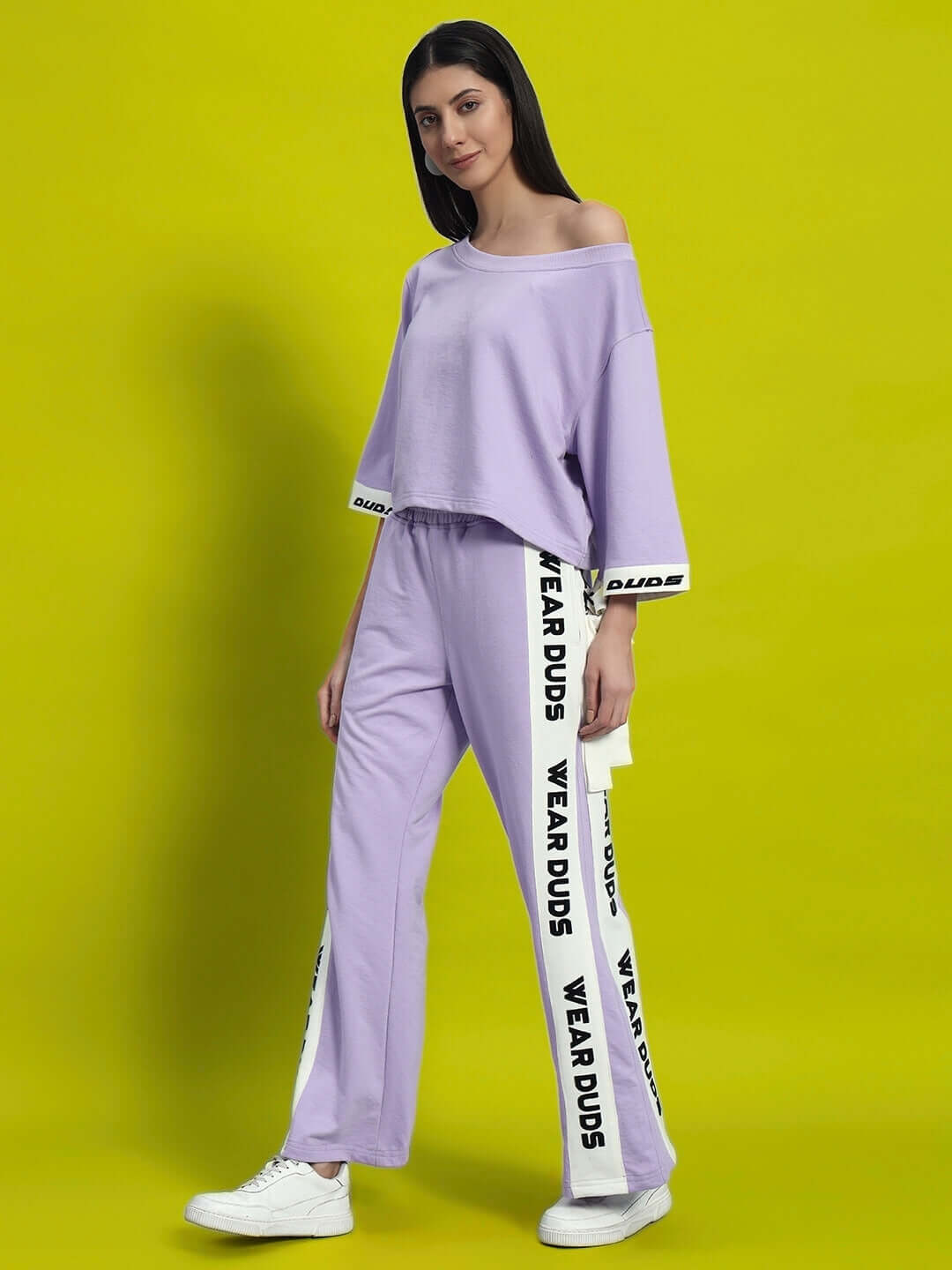 Women's lilac aroma co-ord set with relaxed fit joggers and off-shoulder top, featuring "WEAR DUDS" branding on a bright green background.