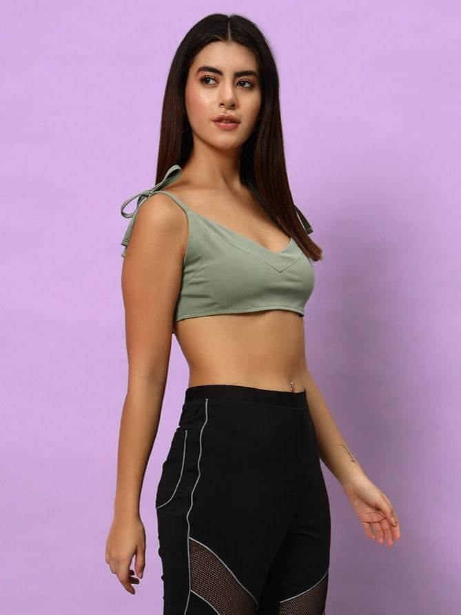 Woman wearing a laurel green Ashley crop-top made of polyester and spandex; styled for a modern, comfortable look.