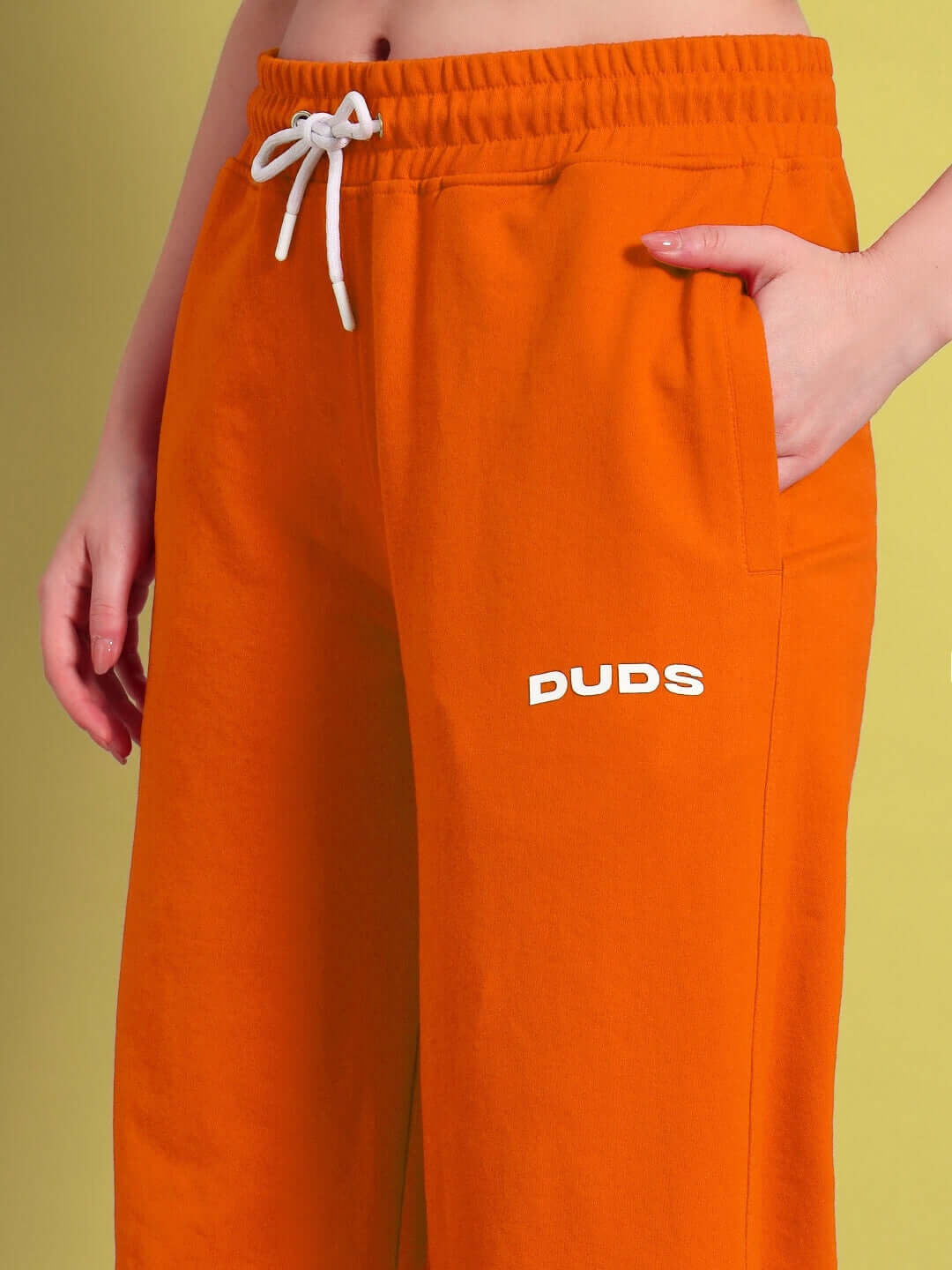 Woman wearing WOMENS AUSTRIAN RELAXED-FIT JOGGERS ORANGE with hand in pocket