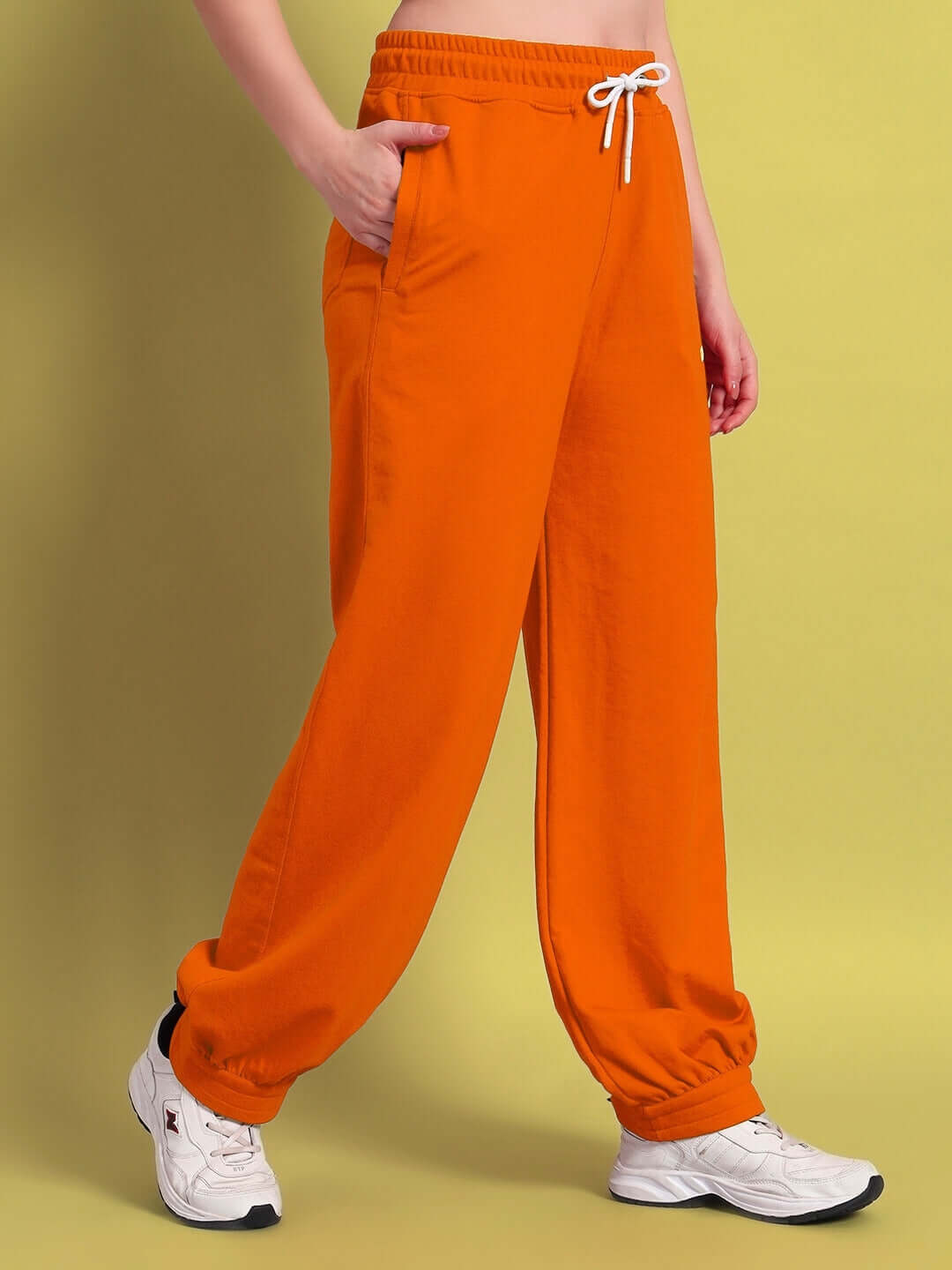 Woman wearing WOMENS AUSTRIAN RELAXED-FIT JOGGERS ORANGE showing their vibrant color and comfortable fit.