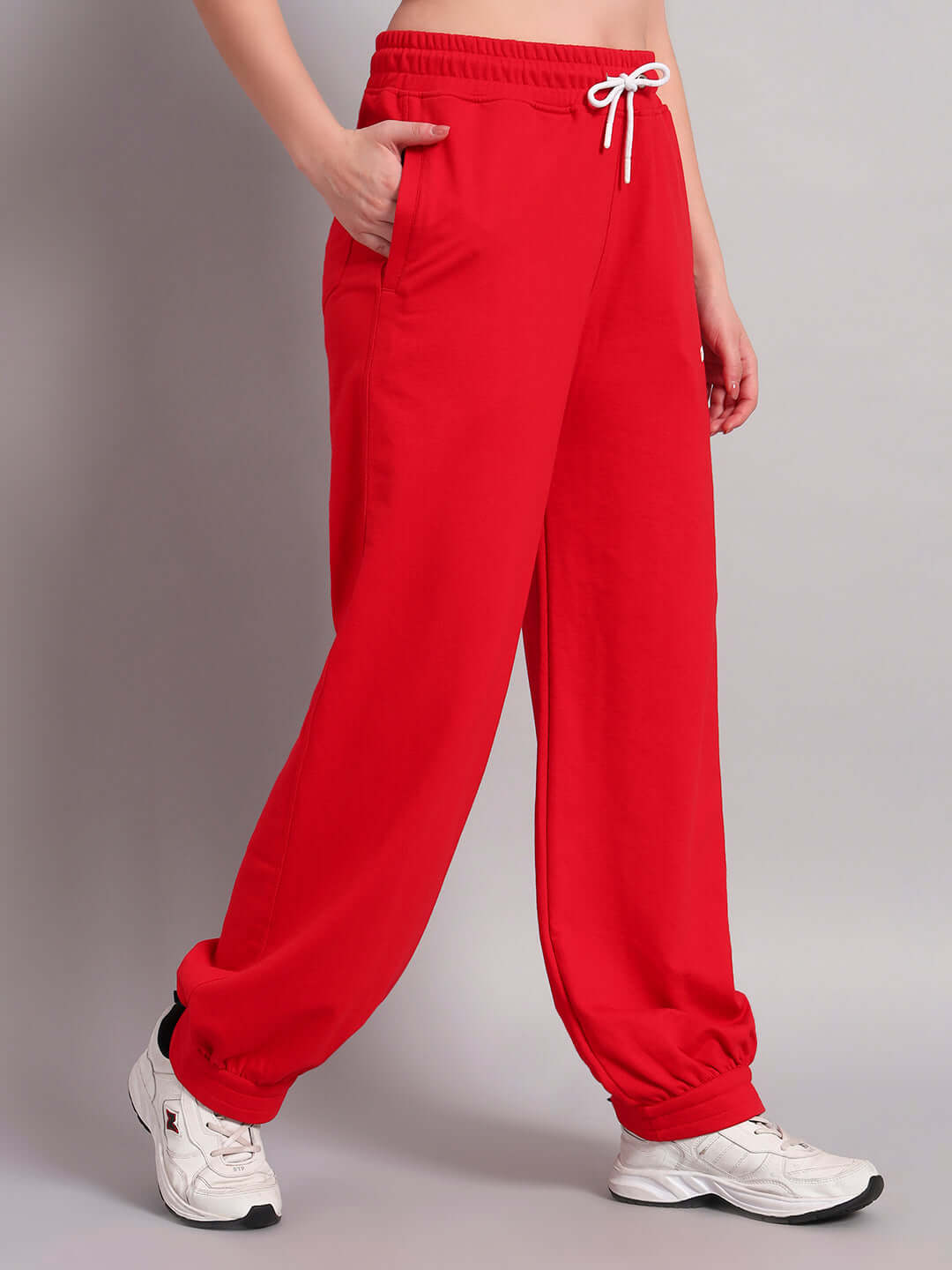 Woman wearing WOMENS AUSTRIAN RELAXED-FIT JOGGERS RED with white sneakers, showcasing a relaxed silhouette and sporty edge for casual outings.
