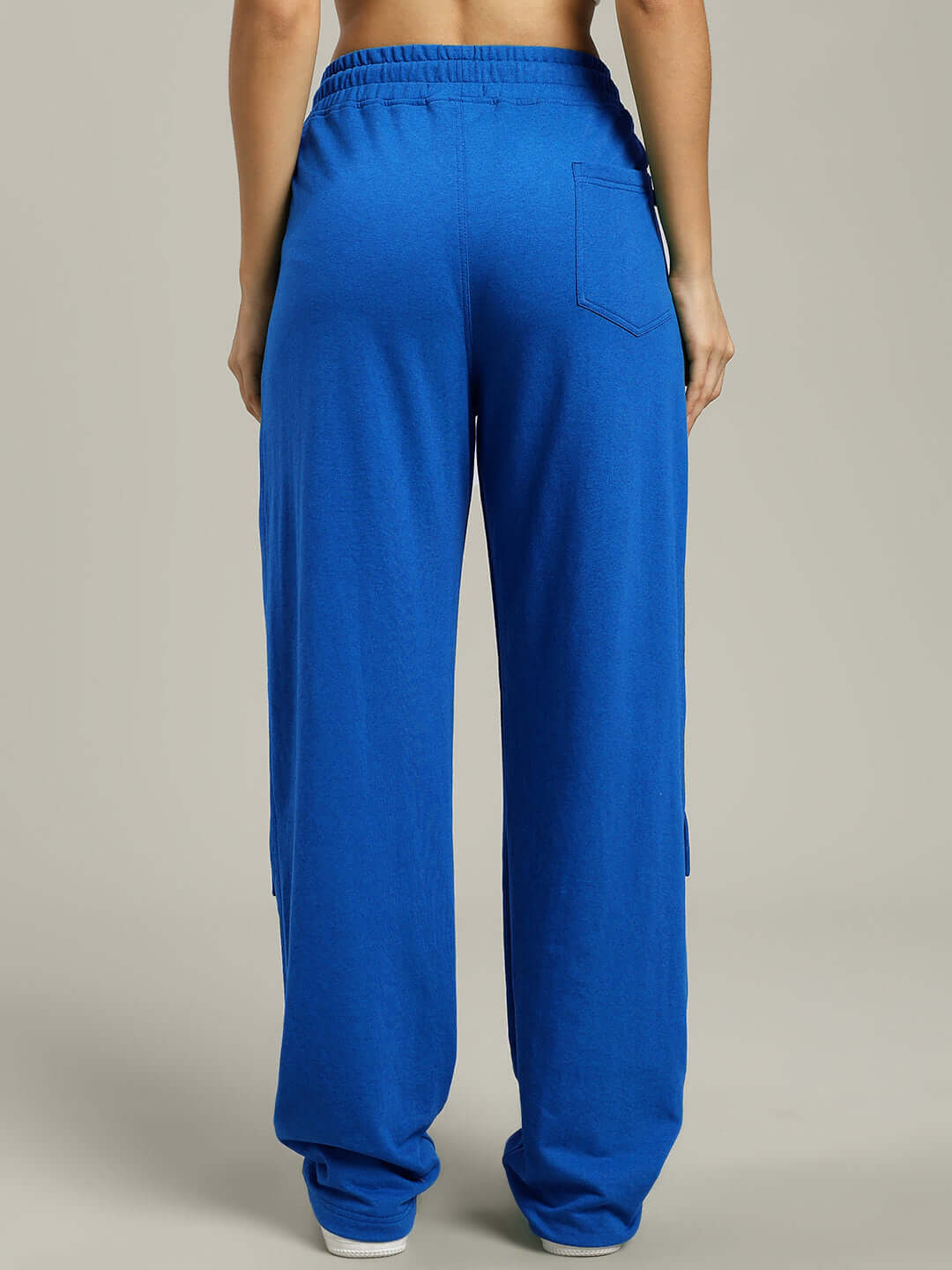 Back view of women's blue baggy jogger pants with flap pocket detail, made-to-order by DUDS.