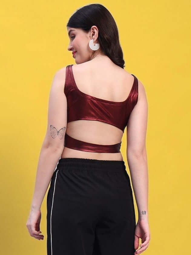Back view of a maroon metallic crop top for women, featuring a stylish strap design, paired with black pants against a yellow background.