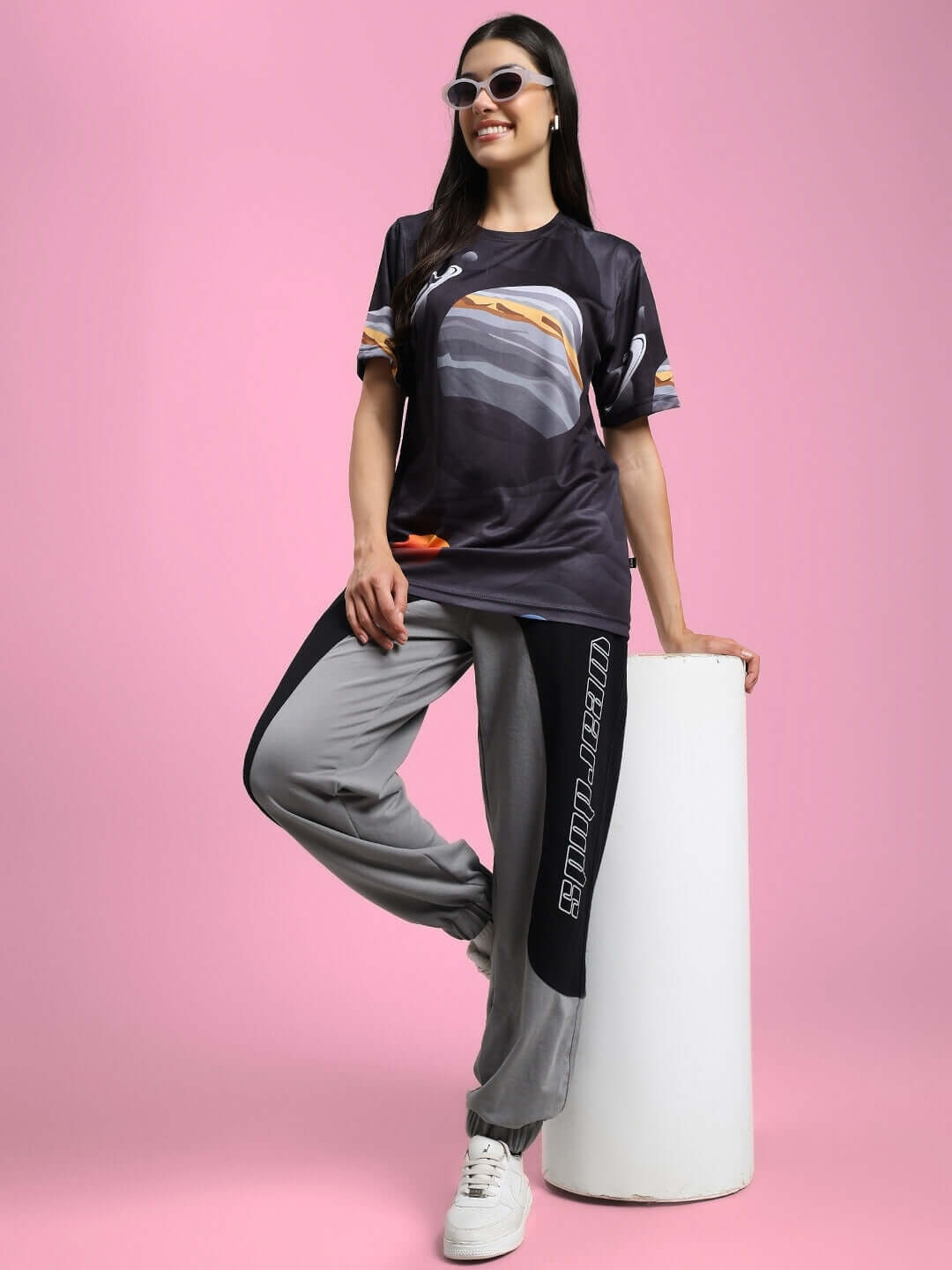 Woman wearing Womens Berlin Relaxed Fit Joggers Black Grey posing stylishly against pink background