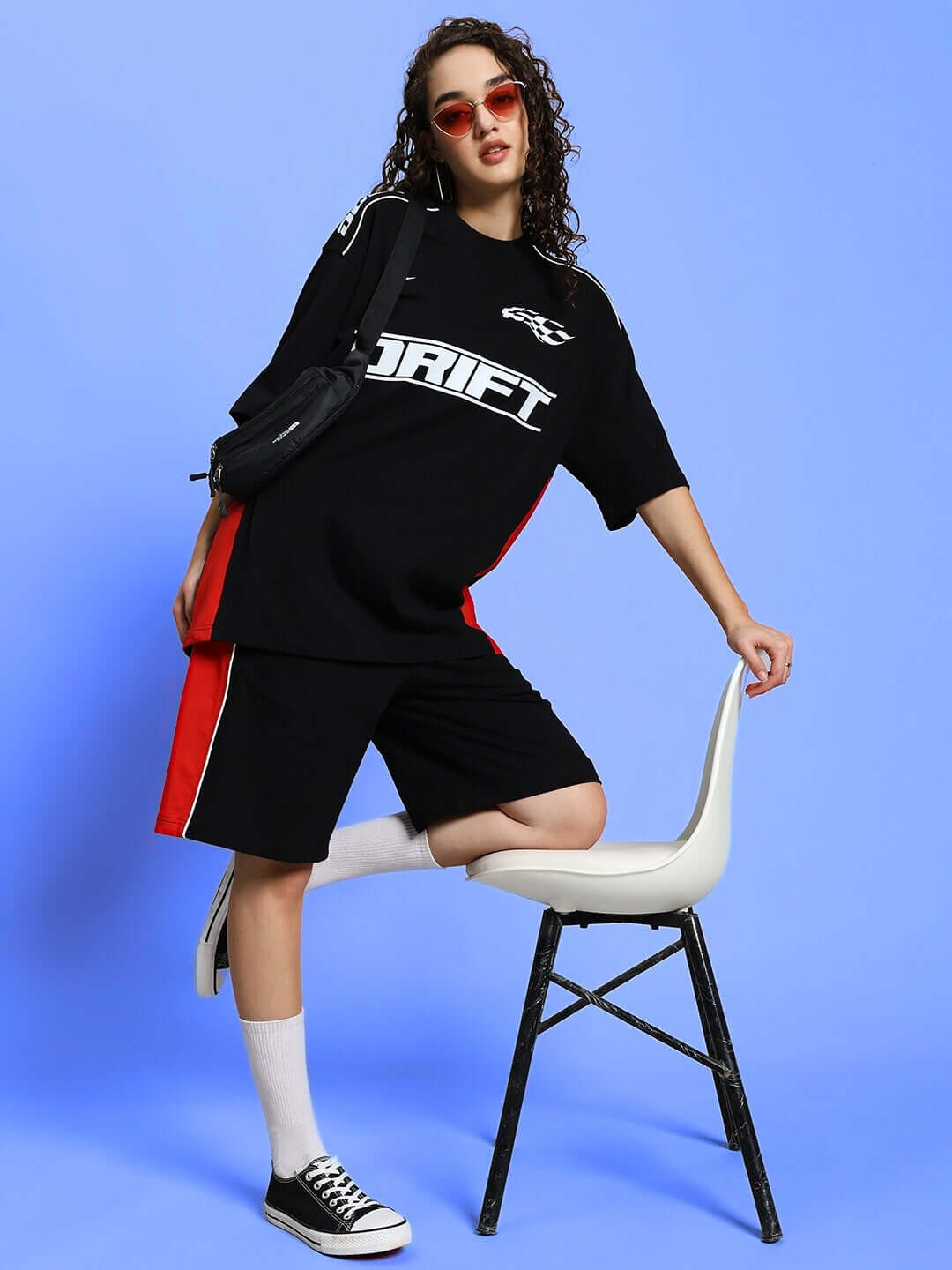 Model wearing Women's Drift Over-sized T-Shirt in black with red accents, trendy urban look with sunglasses