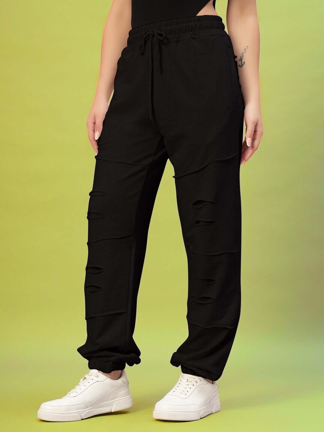 Model wearing Women's DUDS Graze Joggers in black, featuring a relaxed fit with a drawstring waist and distressed design.