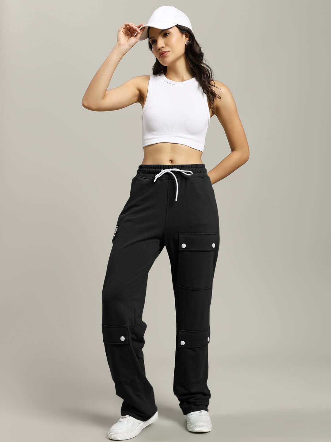 Model wearing women's black flap pocket baggy joggers with drawstring waist and white sneakers.
