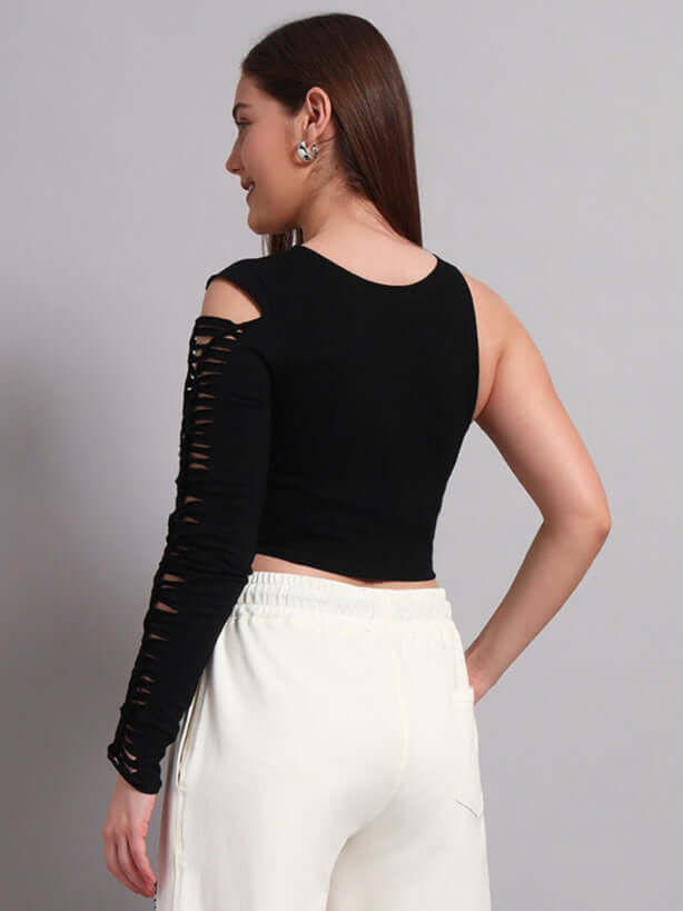 Woman wearing a black frayed designer top with one sleeve, made from premium cotton French terry lycra, paired with white pants.