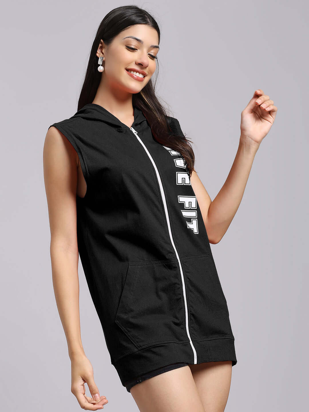 Woman wearing WOMEN'S LIVE FIT GYM HOODED T-SHIRT BLACK, showcasing sleeveless design and zipper front, perfect for workouts.