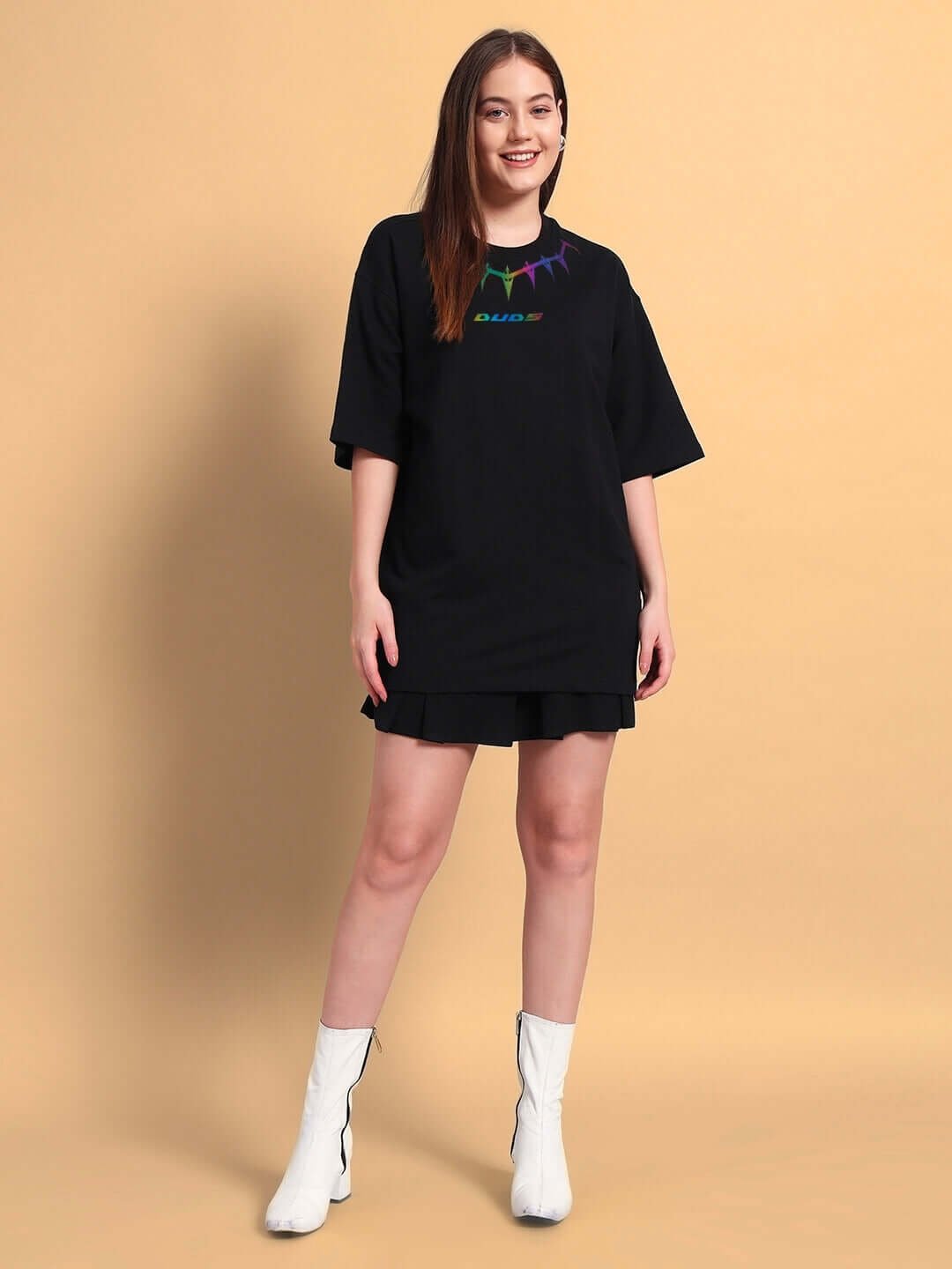 Model wearing women's Black Panther Reflector oversized t-shirt made from premium cotton fabric, styled with white boots on a beige background.