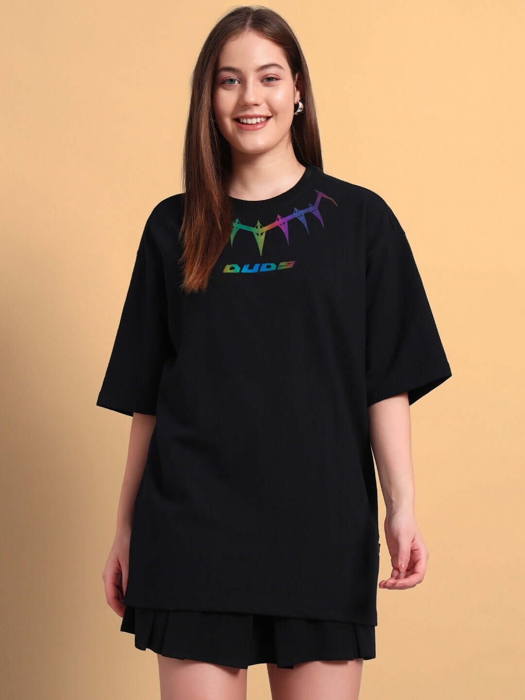 Model wearing women's black oversized T-shirt with colorful graphic, made of premium cotton fabric, perfect for casual wear.