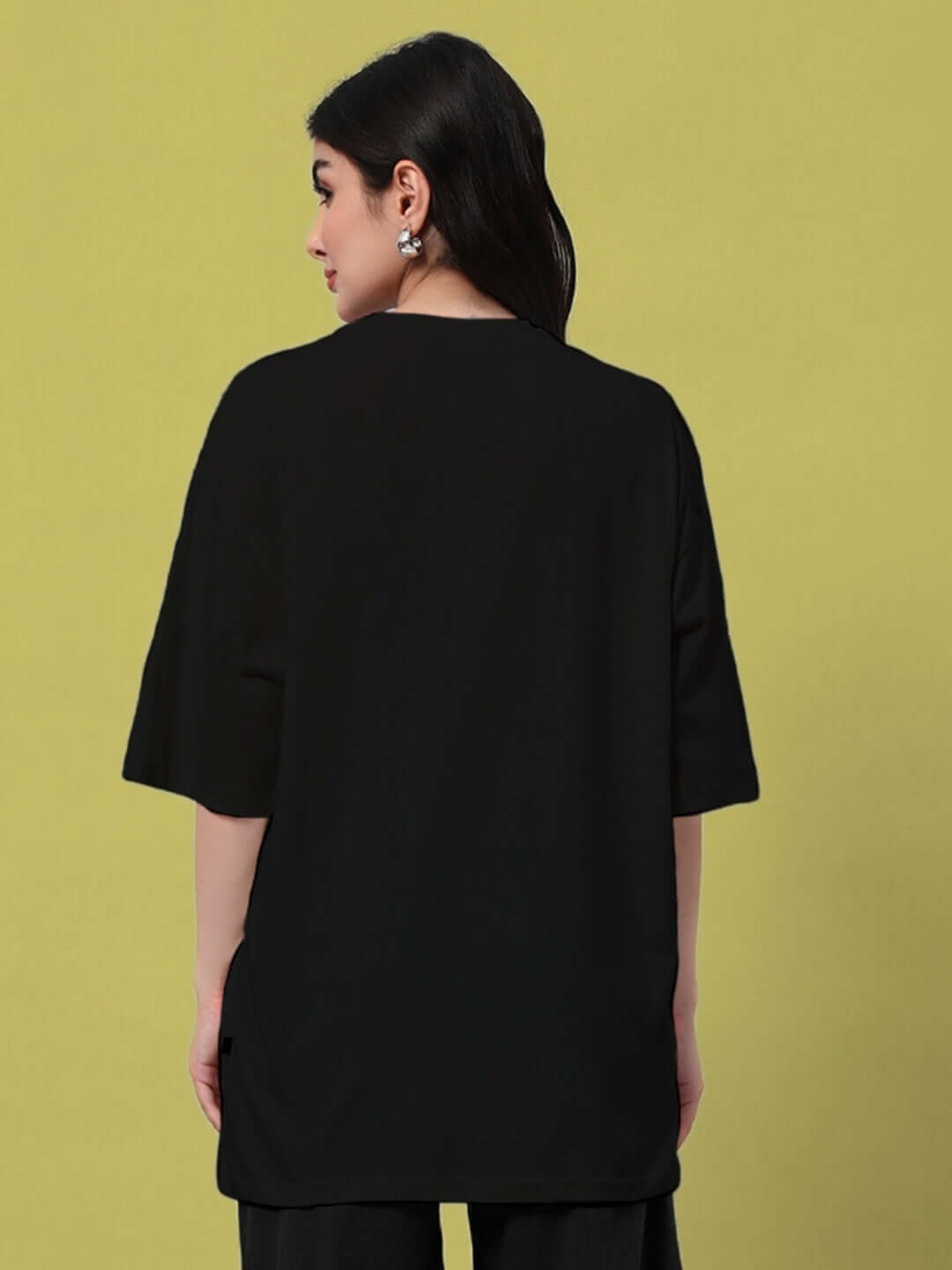 Rear view of woman wearing black oversized t-shirt, showcasing relaxed fit and lightweight cotton fabric, perfect for summer style.