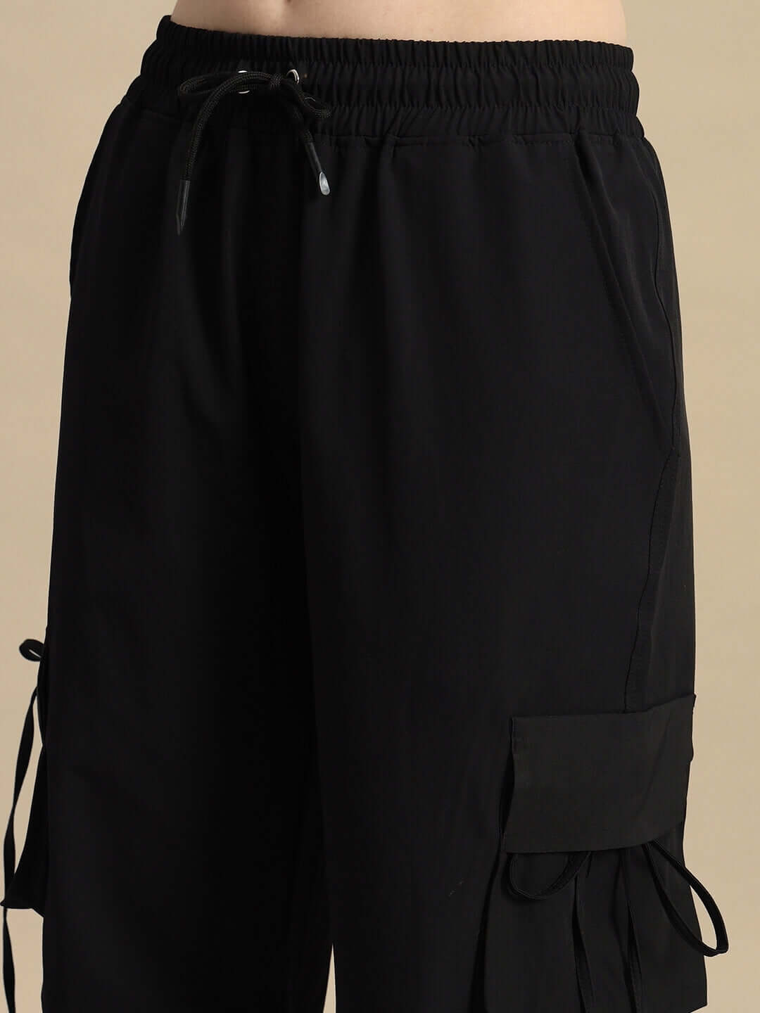 Black women's ramrod parachute cargo pants with drawstring waistband and pockets, ideal for customized fit.