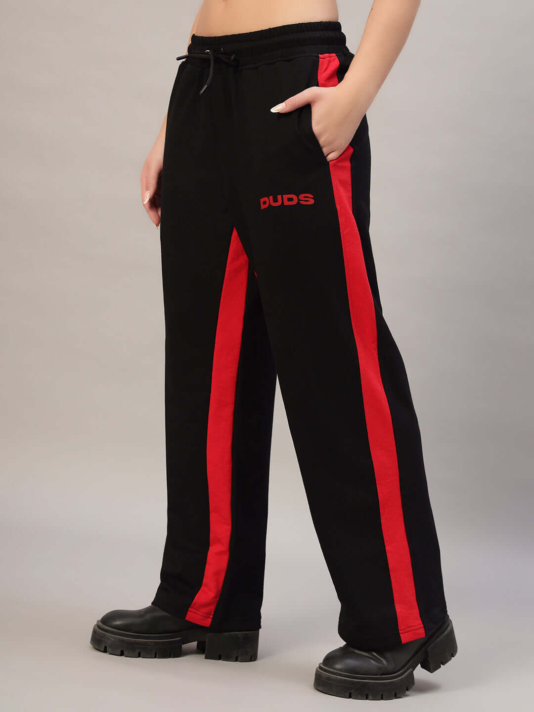 Woman wearing DUDS black-red side seam baggy joggers, showcasing custom fit convenience and stylish casual wear.