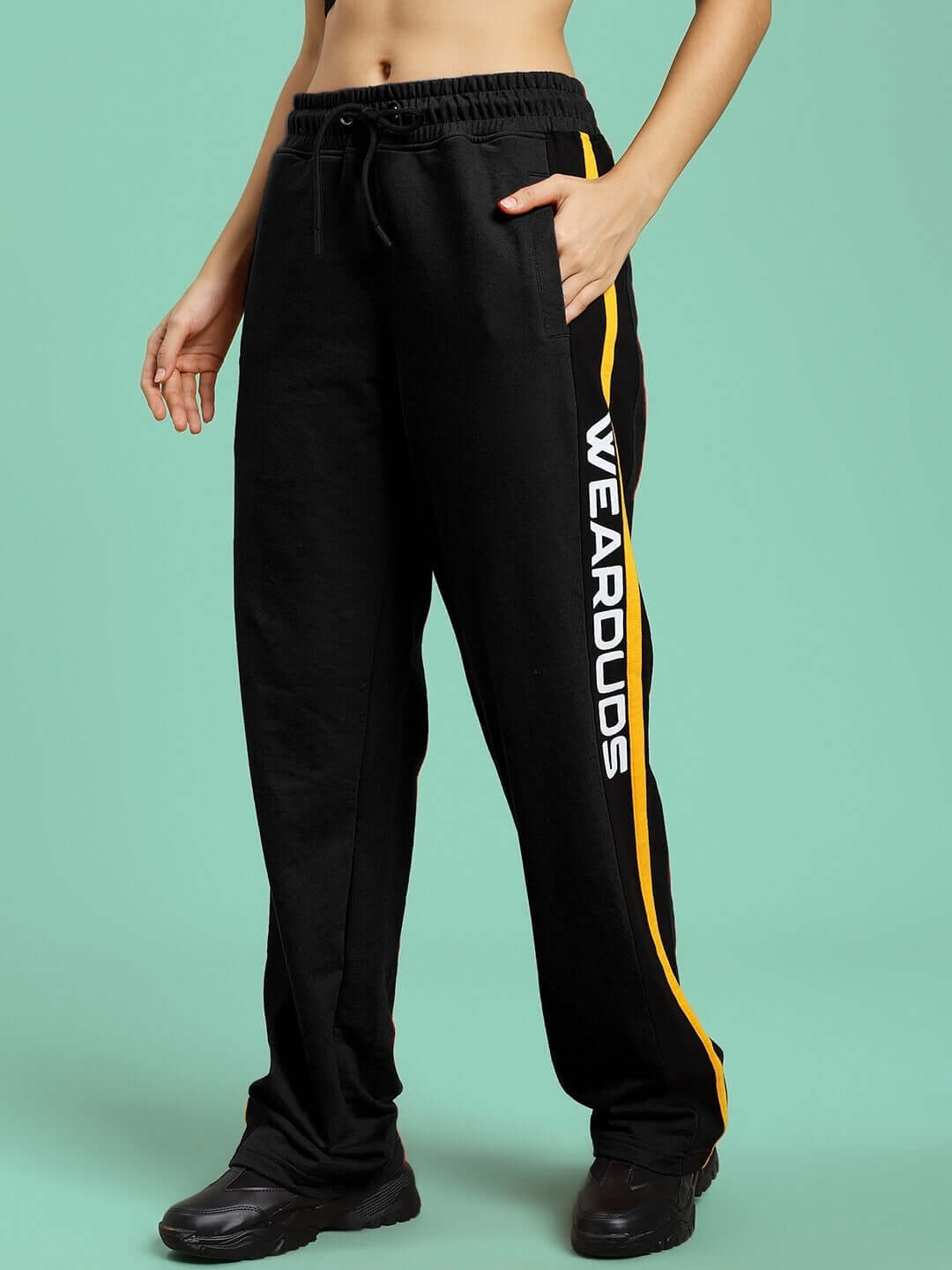 Woman wearing WOMENS ROGER RELAXED-FIT JOGGERS BLACK with side pockets, perfect for workouts or casual outings.