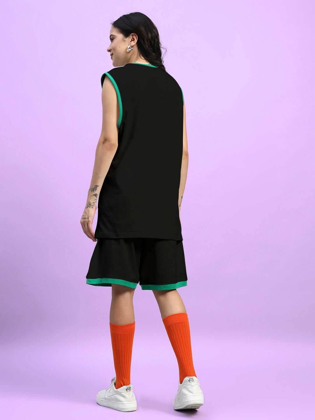 Model wearing WOMENS STAY POSITIVE CO-ORD SET BLACK with orange socks, showcasing stylish streetwear fashion for casual outings.