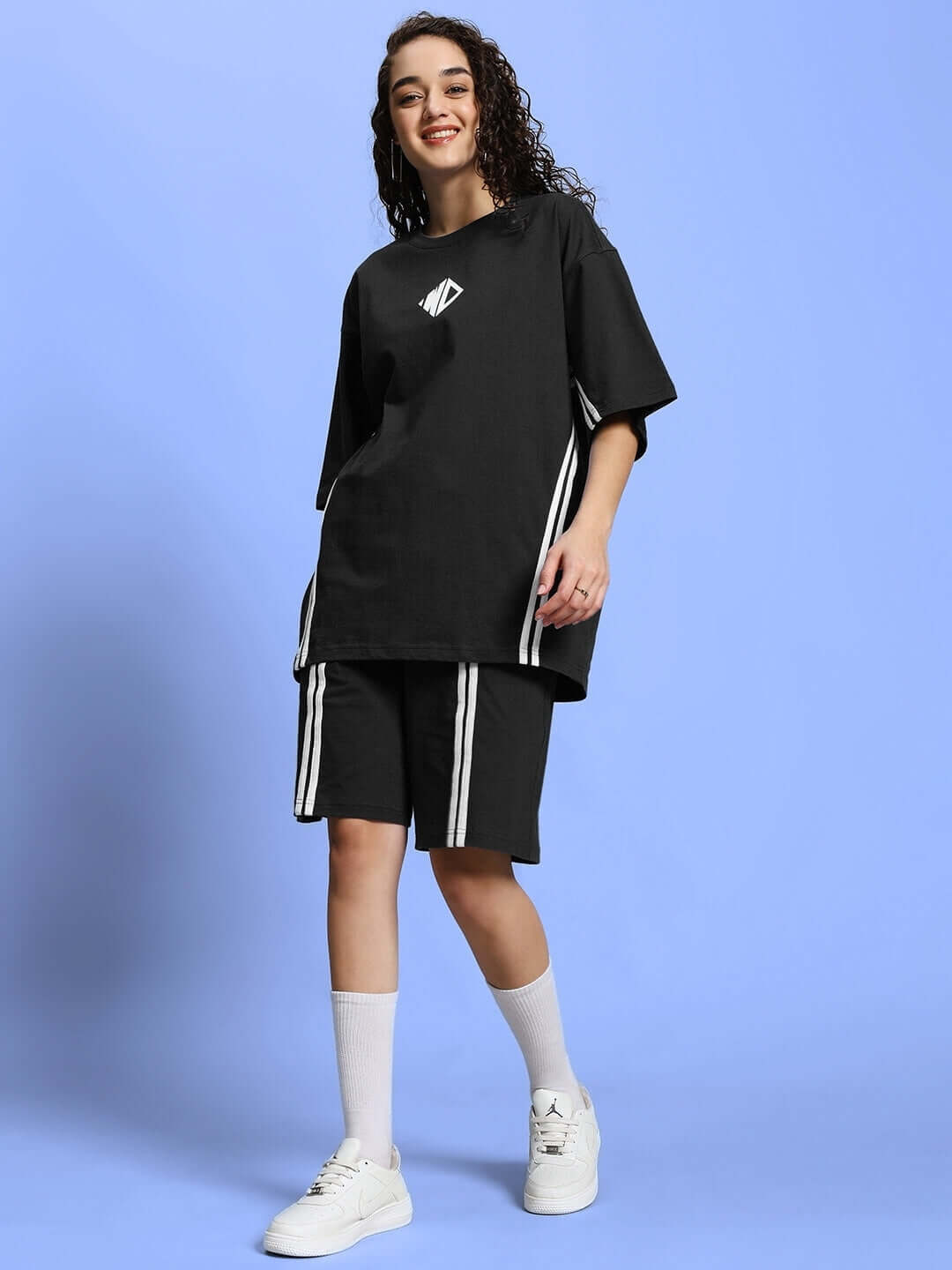 Woman wearing WOMEN'S OUTLOOK SUMMER CO-ORD SHORTS SET BLACK with stripes, featuring relaxed-fit t-shirt and shorts for casual style.