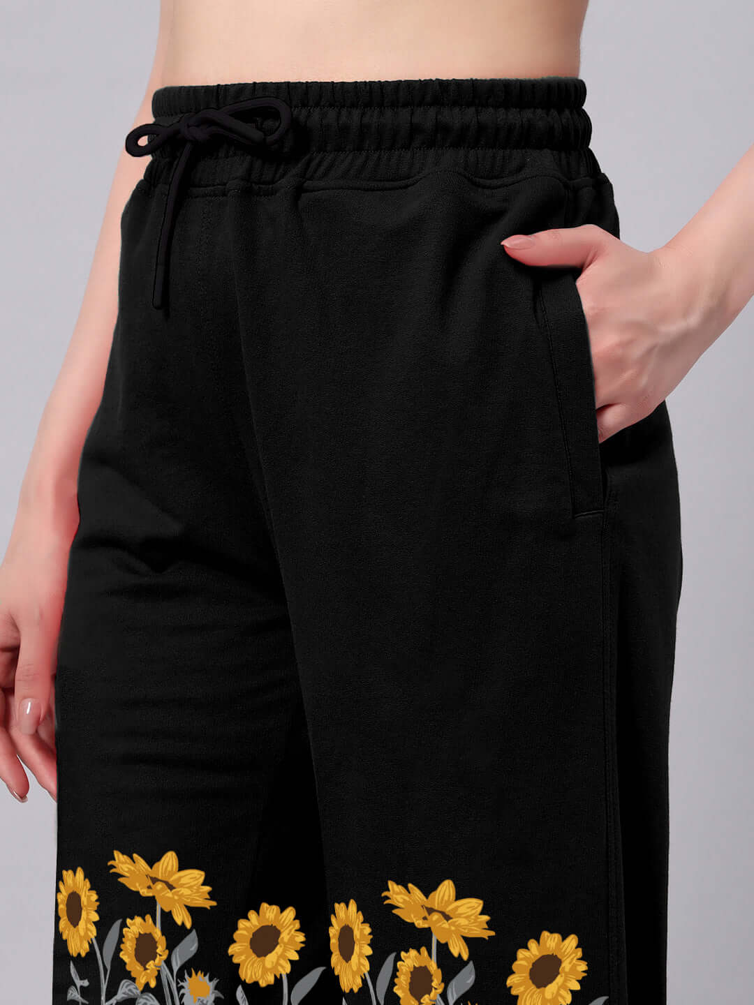 Women's black joggers with sunflower design, relaxed fit, adjustable drawstring waist, made-to-order fashion by DUDS.