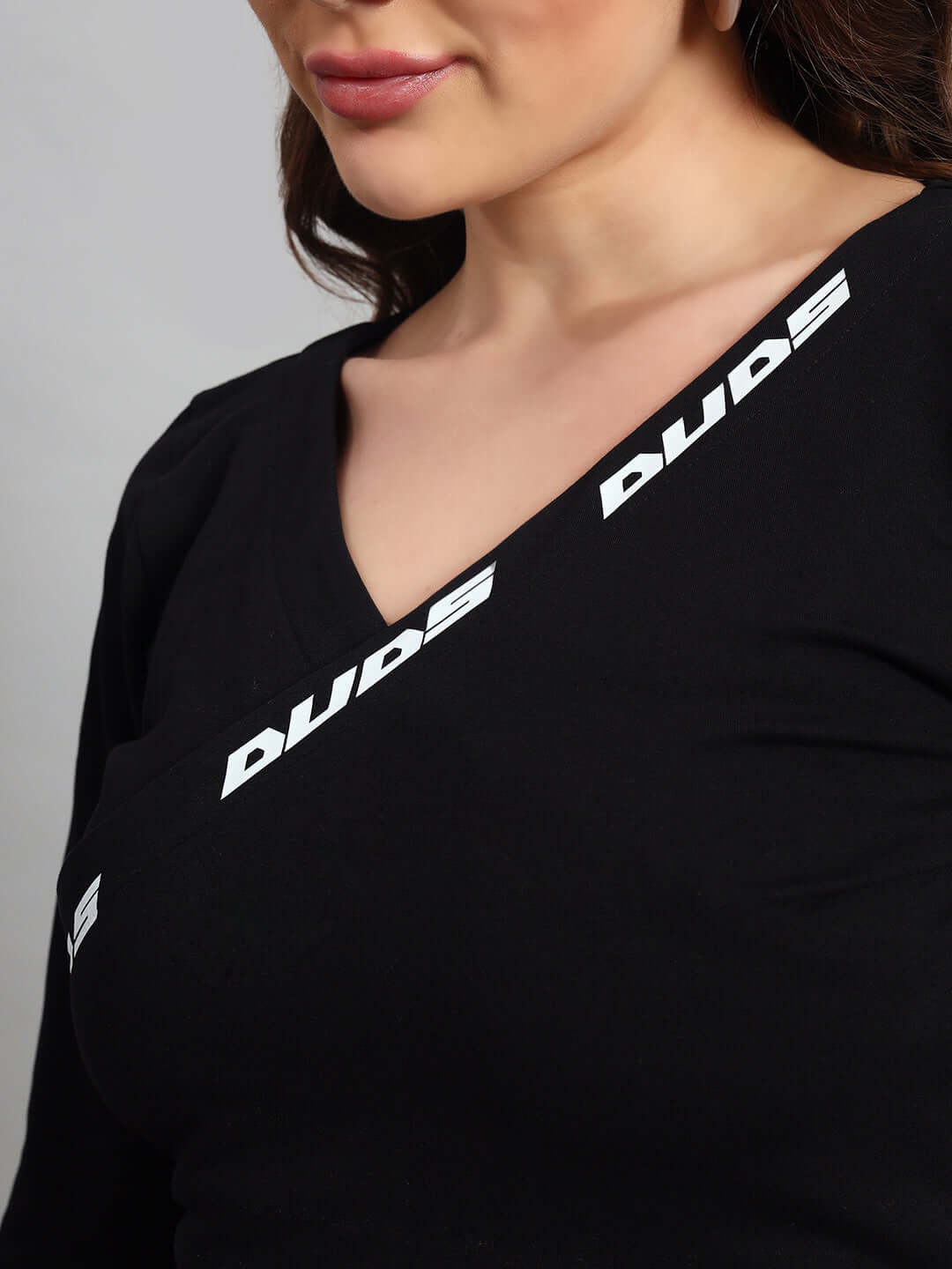 Close-up of a woman wearing a black top with white 'DUDE' text design.