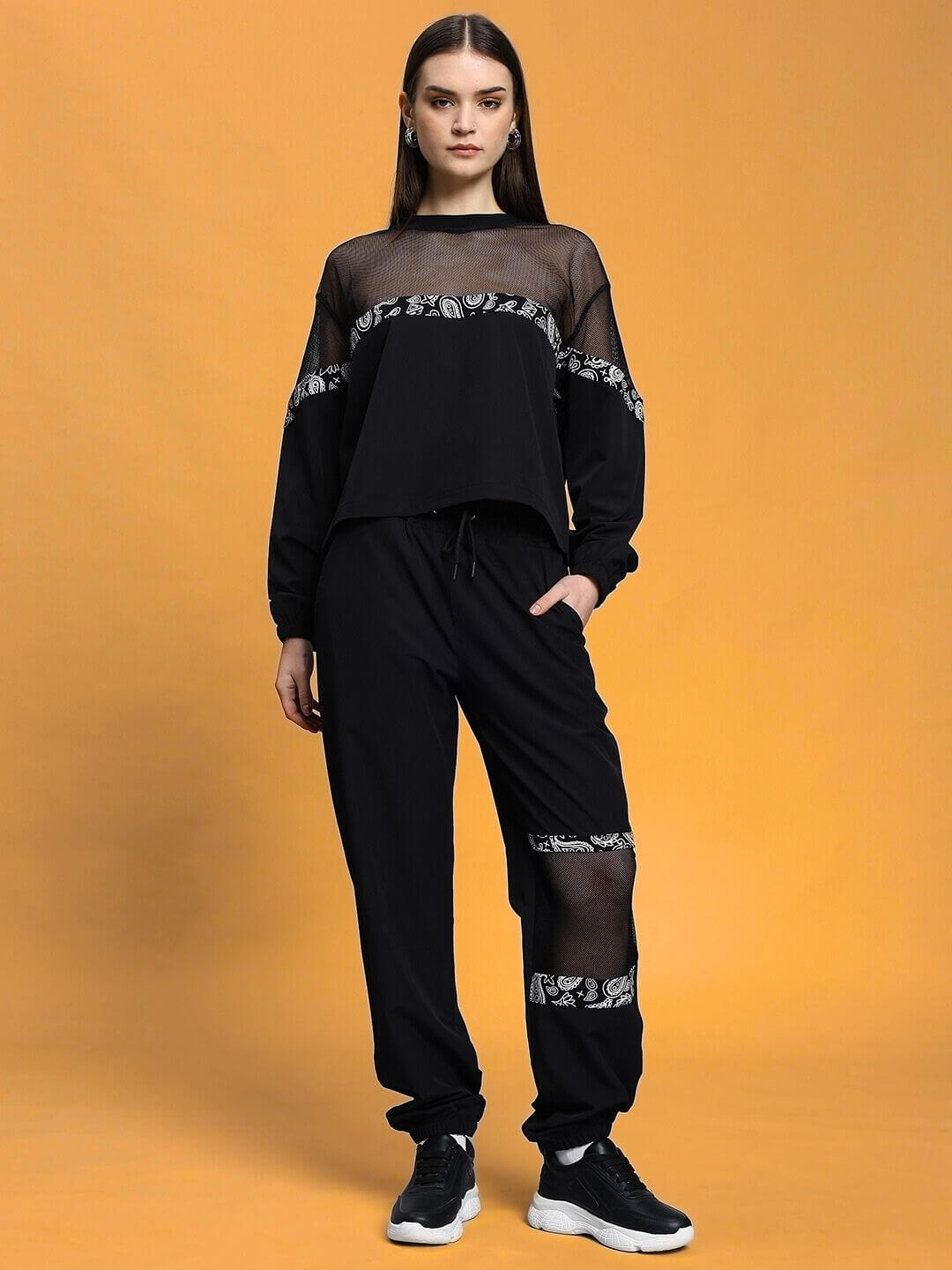 Women's black relaxed fit co-ord set with elasticated waistband, featuring sheer accents, shown from front.