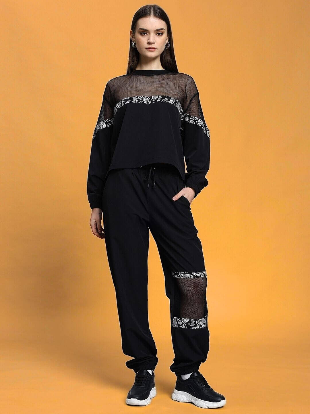 Woman wearing black relaxed fit co-ord set with elastic waistband and drawstring, featuring stylish design accents. Polyester fabric.