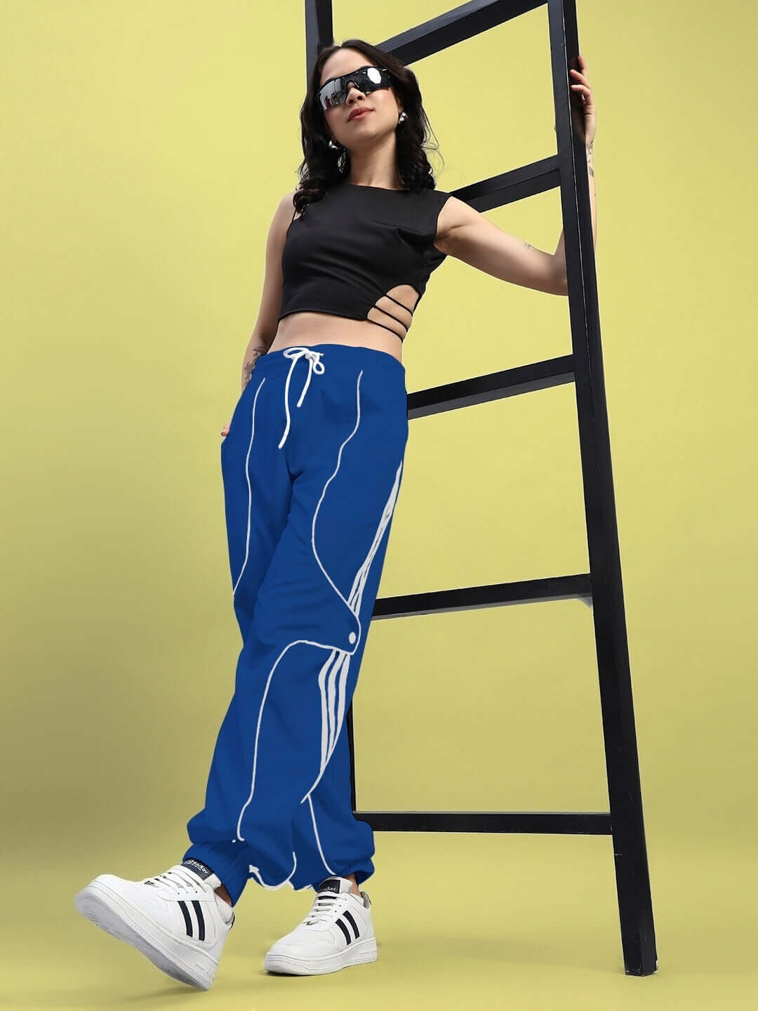 Woman wearing WOMENS BOLSON STRIPES RELAXED-FIT JOGGERS BLUE, standing by a ladder, showcasing sporty casual style with comfort and durability.