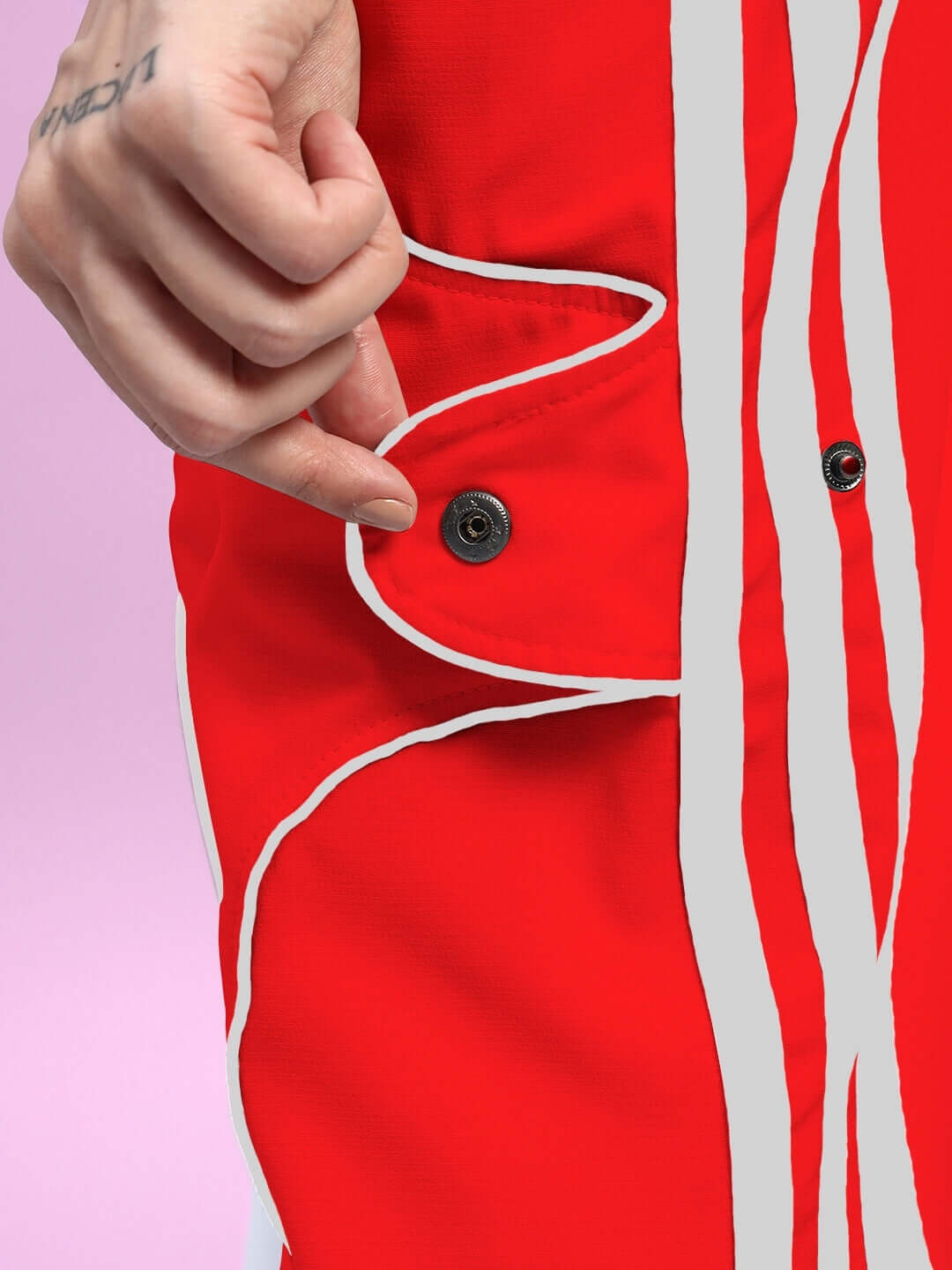 Close-up of red women's joggers with white stripes and a buttoned pocket detail.