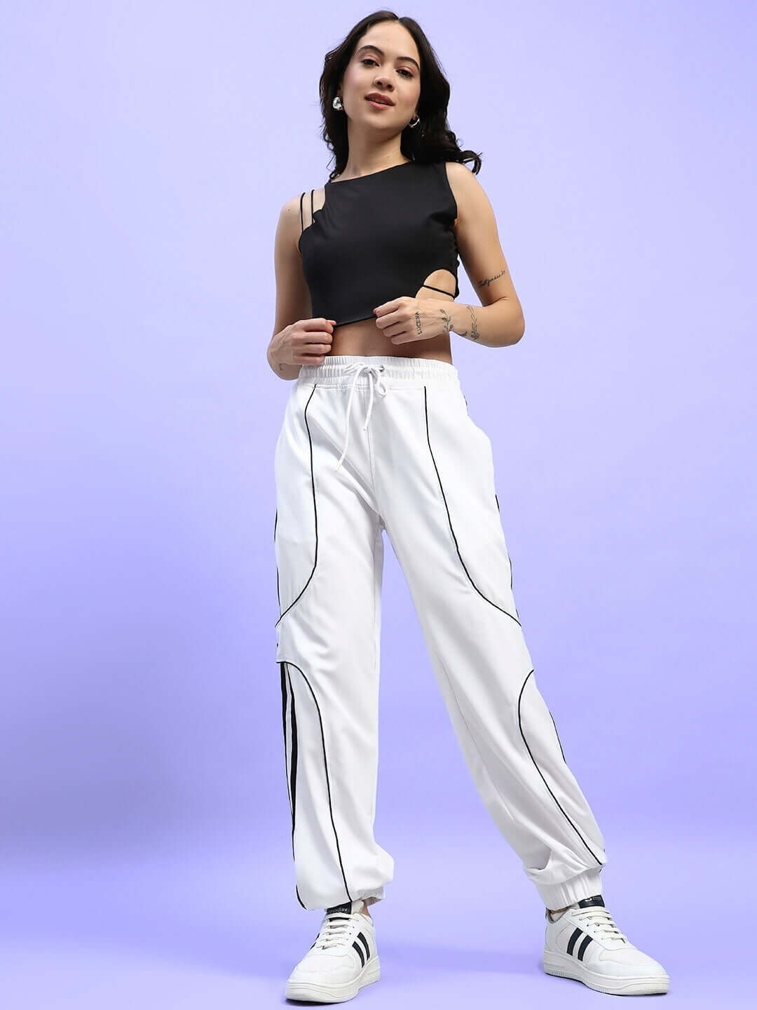 Model wearing WOMEN'S BOLSON STRIPES RELAXED-FIT JOGGERS WHITE with black top, showcasing casual fashion style in a studio setting.