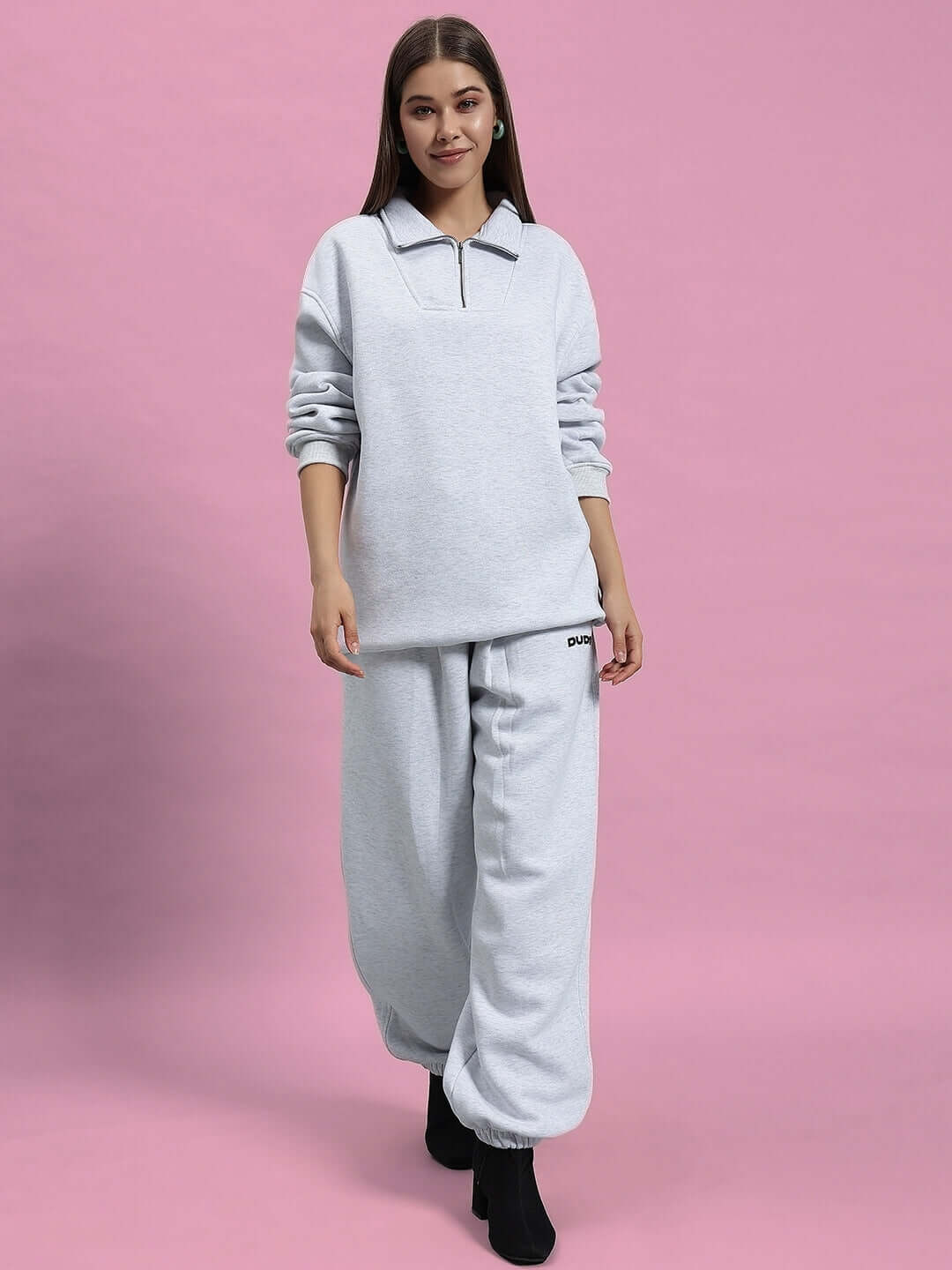 Woman wearing Women Bona-Fide Fleece Co-ord Melange Grey, featuring soft fleece with ribbed cuffs and a relaxed fit, against pink backdrop.