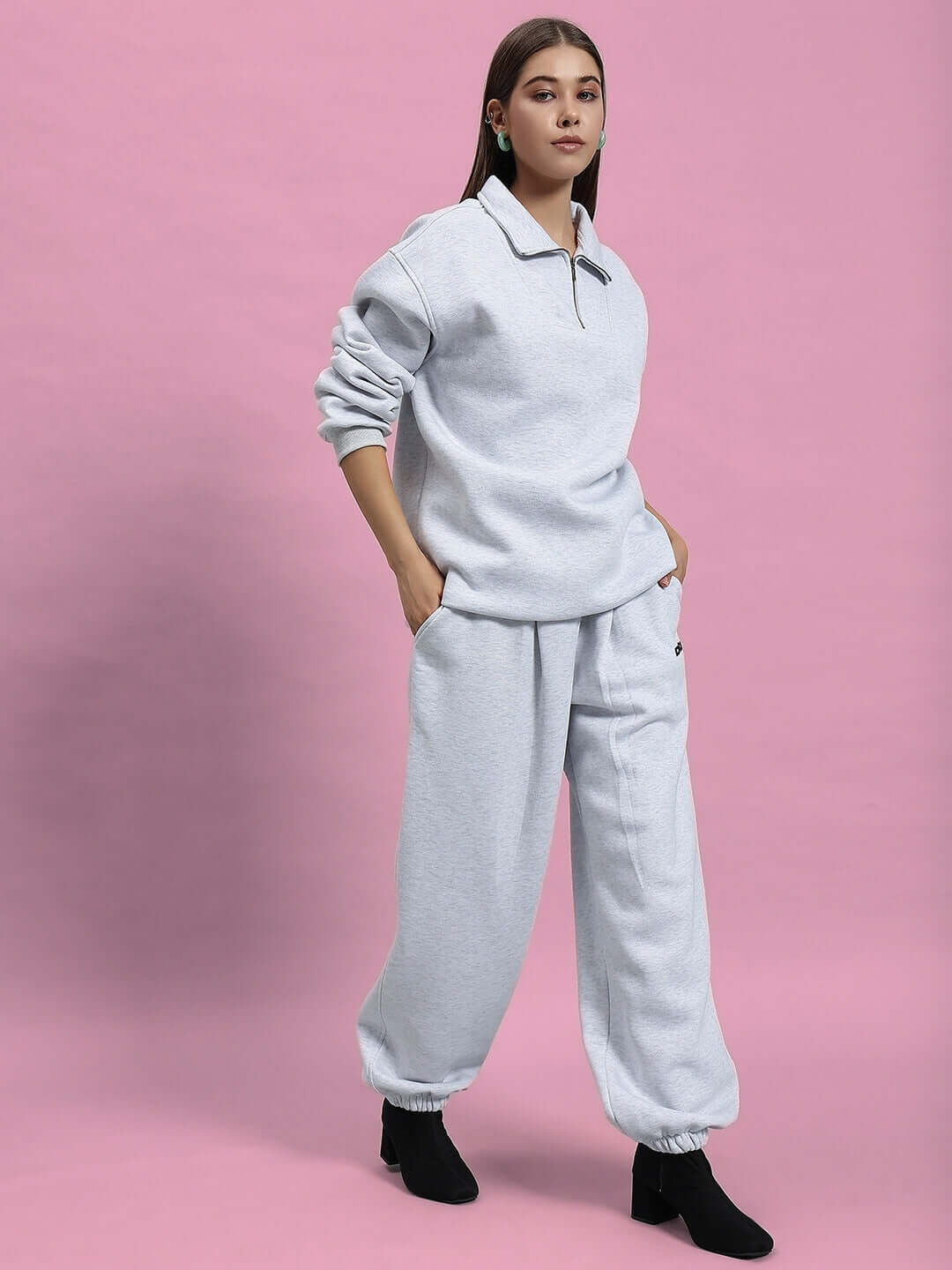 Model wearing WOMEN BONAFIDE FLEECE CO-ORD MELANGE GREY, showcasing cozy and stylish fleece set with a modern fit on pink background.