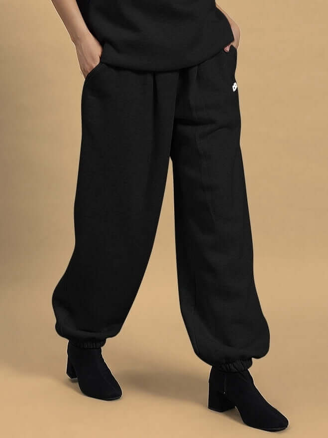 Model wearing WOMEN'S BONA-FIDE FLEECE PANT BLACK with elastic waistband and relaxed fit.
