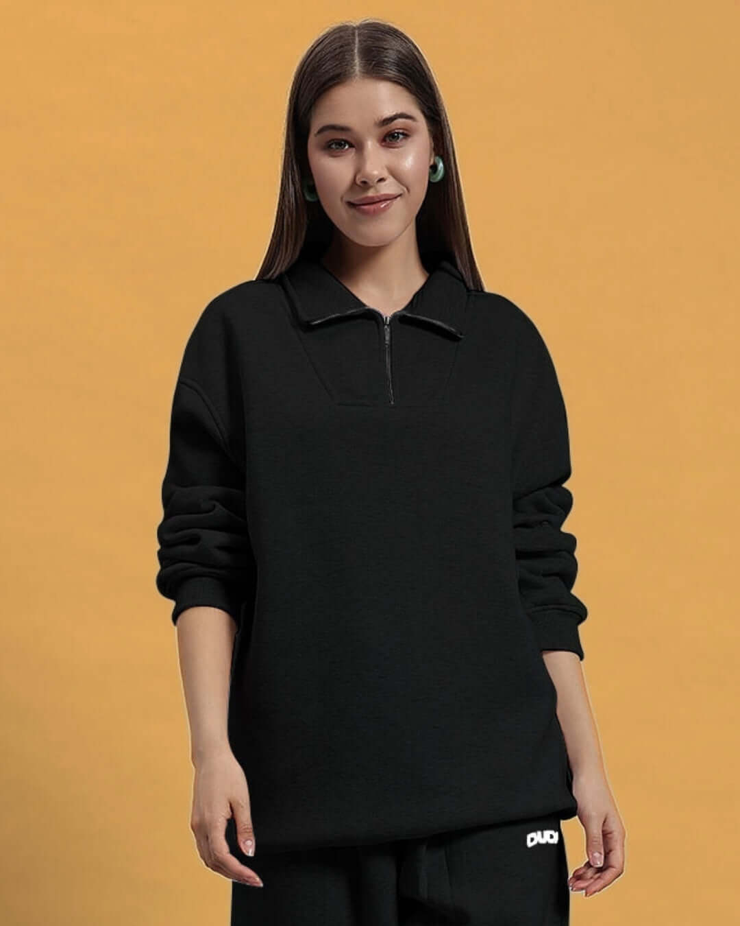 Woman wearing a black women's bona-fide sweatshirt by DUDS, showcased on a beige background.