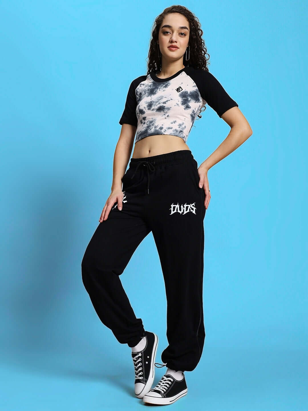 Woman wearing casual black and white tie-dye matching set against blue background