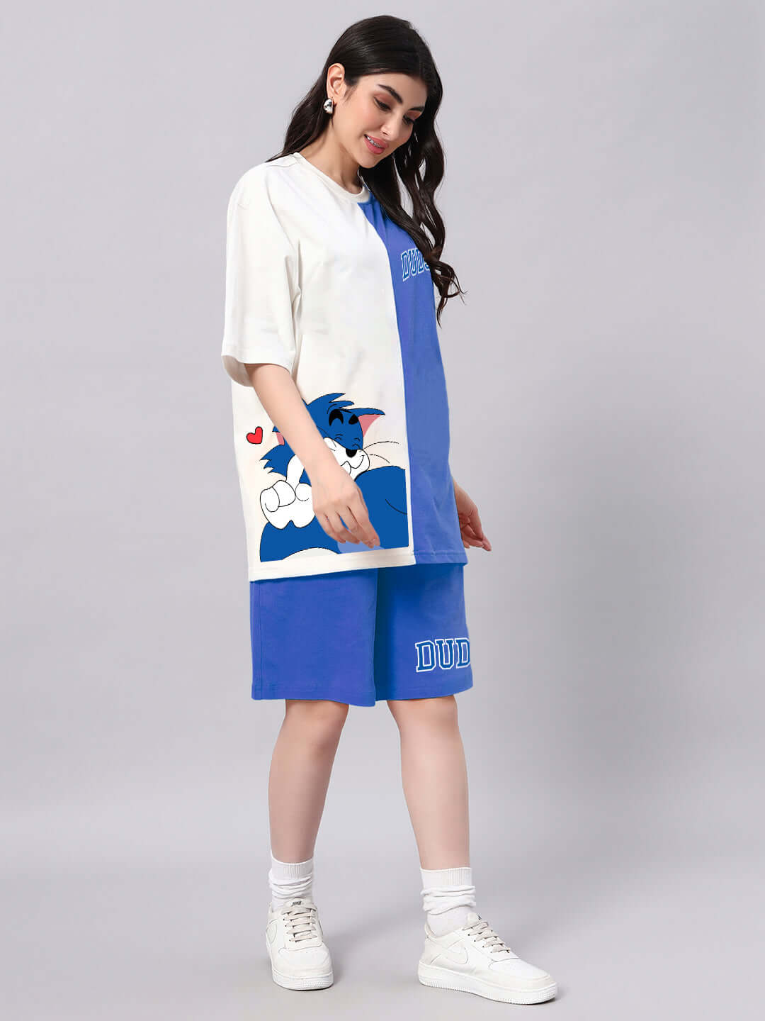 Woman wearing WOMEN'S CAPER TOM CO-ORD SET BLUE OFF-WHITE with cartoon detailing, showcasing summer fashion style.
