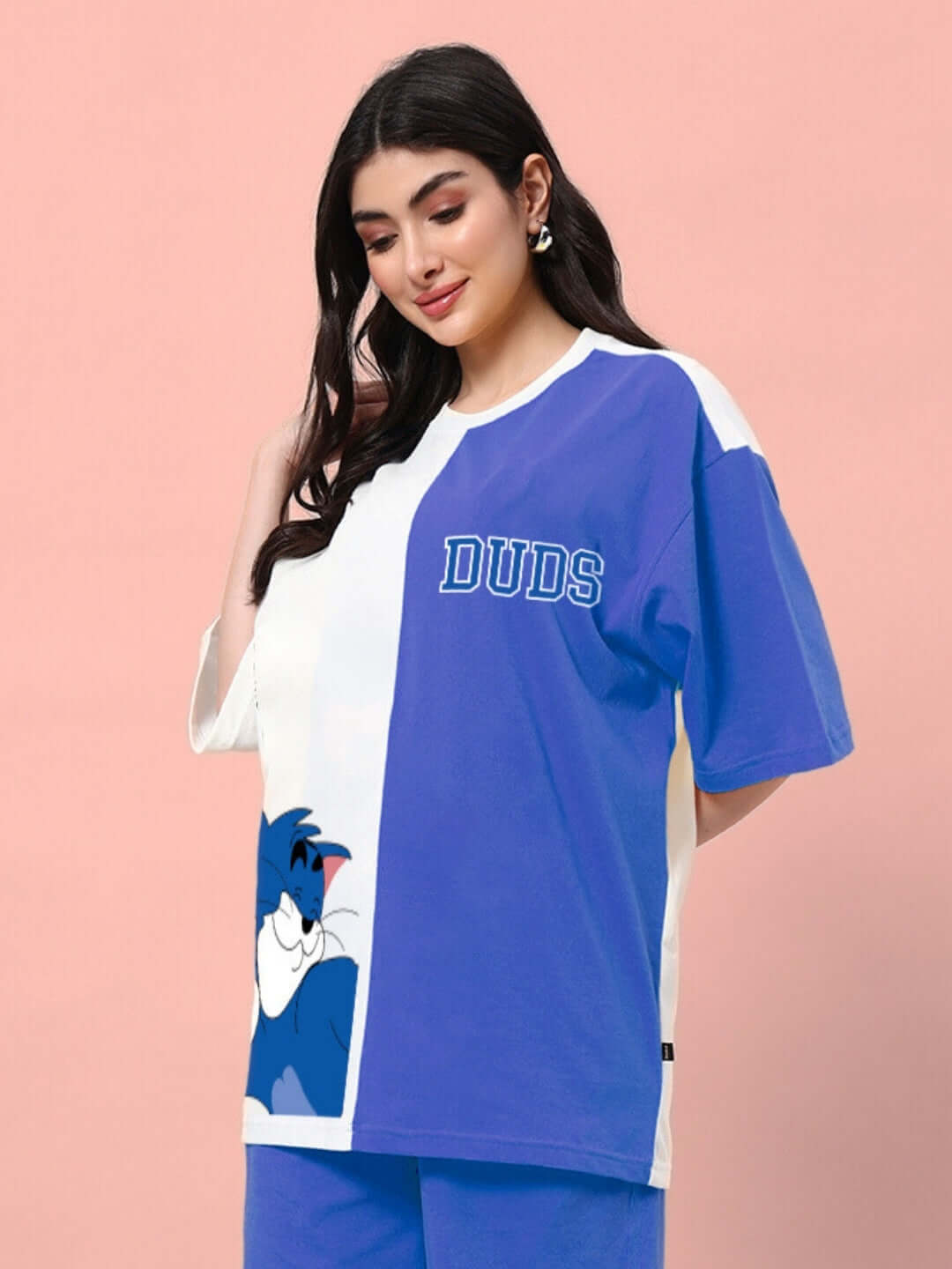 Model wearing a blue and off-white oversized t-shirt with a cartoon character and 'DUDS' text, ideal for a trendy summer look.