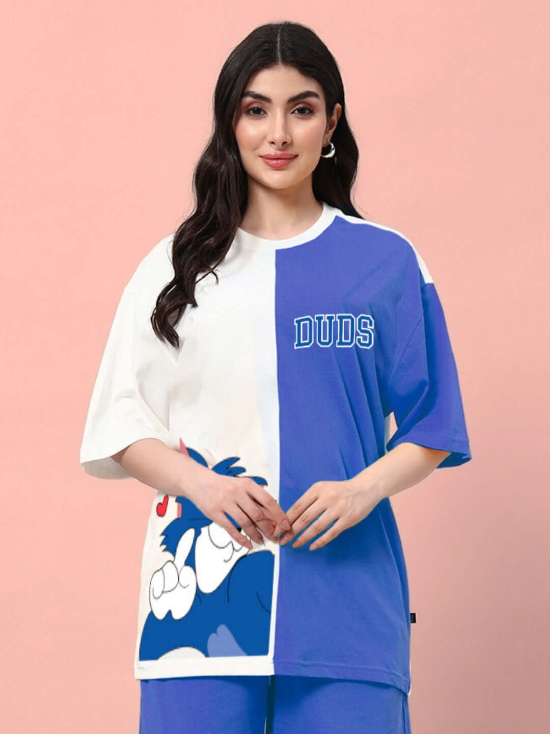Woman wearing a trendy blue and off-white oversized t-shirt with graphic print, perfect for a comfy summer look with breathable cotton.