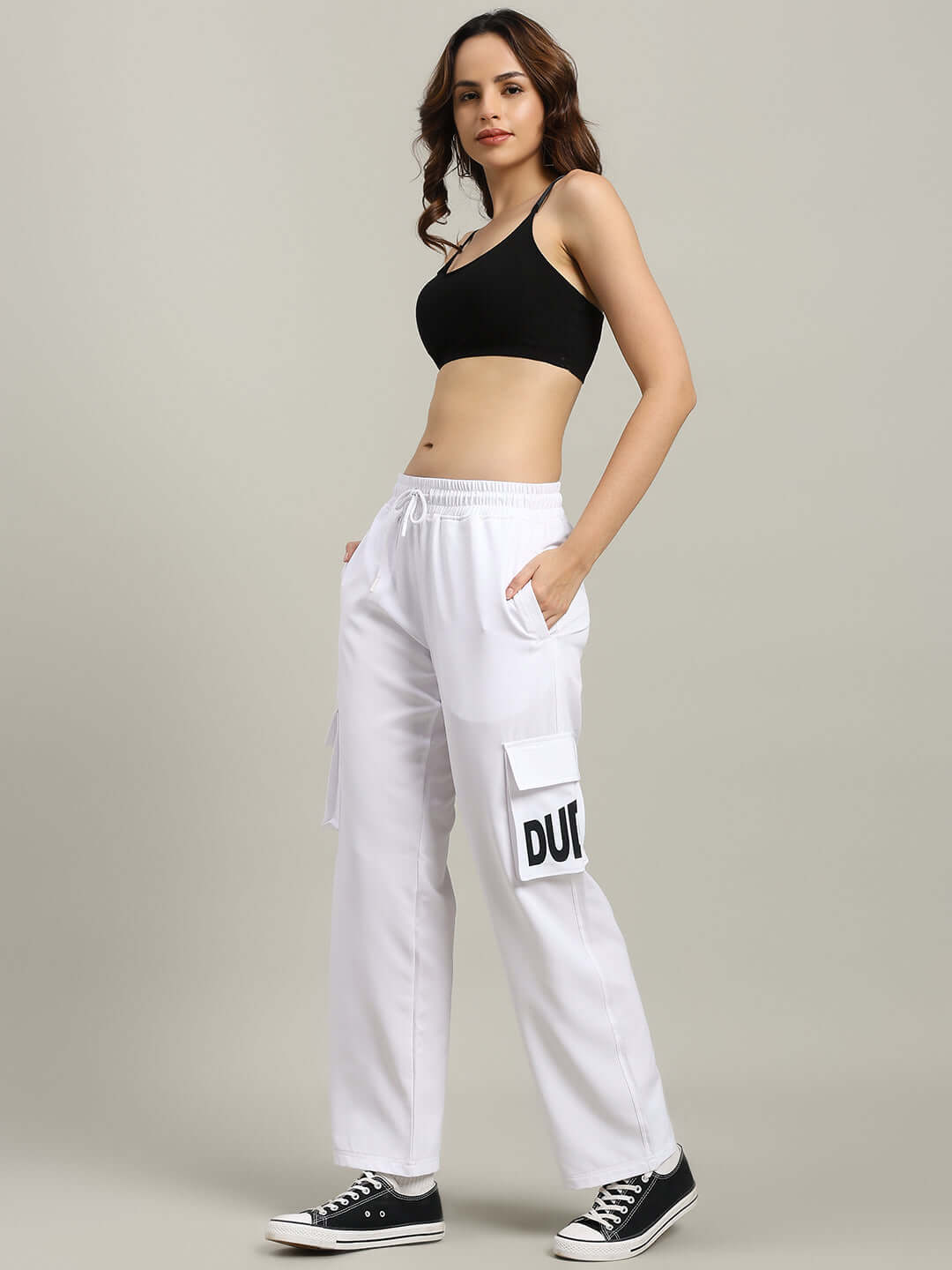 Model wearing WOMEN'S CARMINE RELAXED FIT JOGGER WHITE with casual black top and sneakers, showcasing made-to-order fashion.