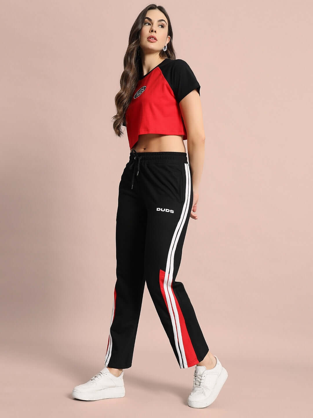 Women's red and black cropped raglan top with sporty design, made from premium cotton, modeled in studio setting.