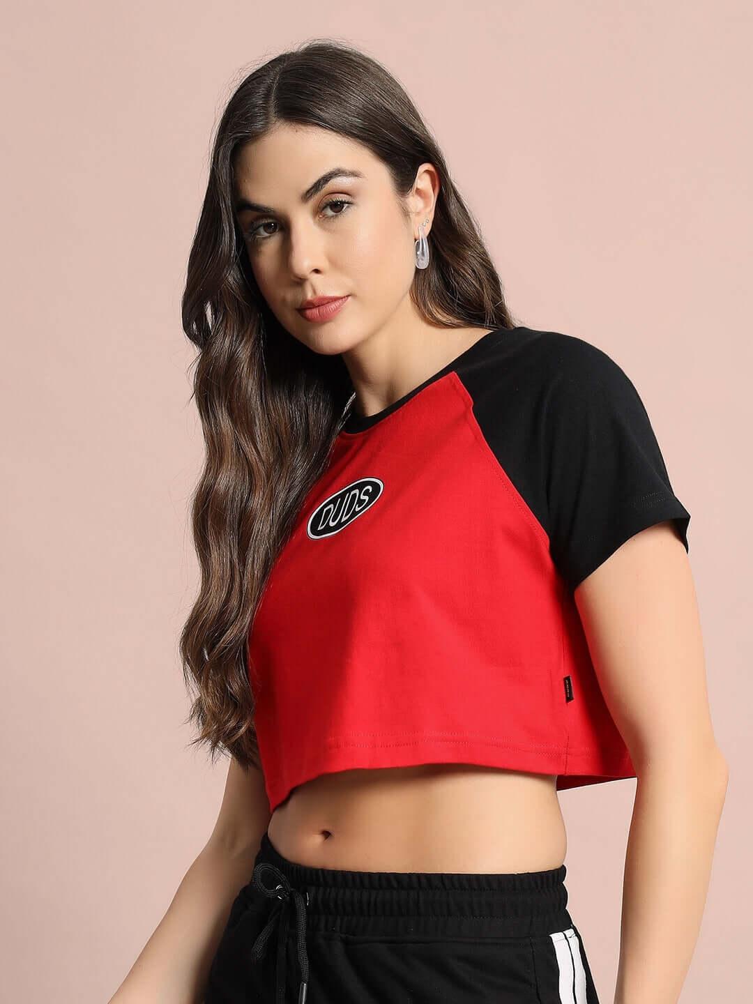 Model wearing Women's Challenger Raglan Crop-Top in red and black, made of premium cotton fabric, 220 GSM, by Color By Colours.